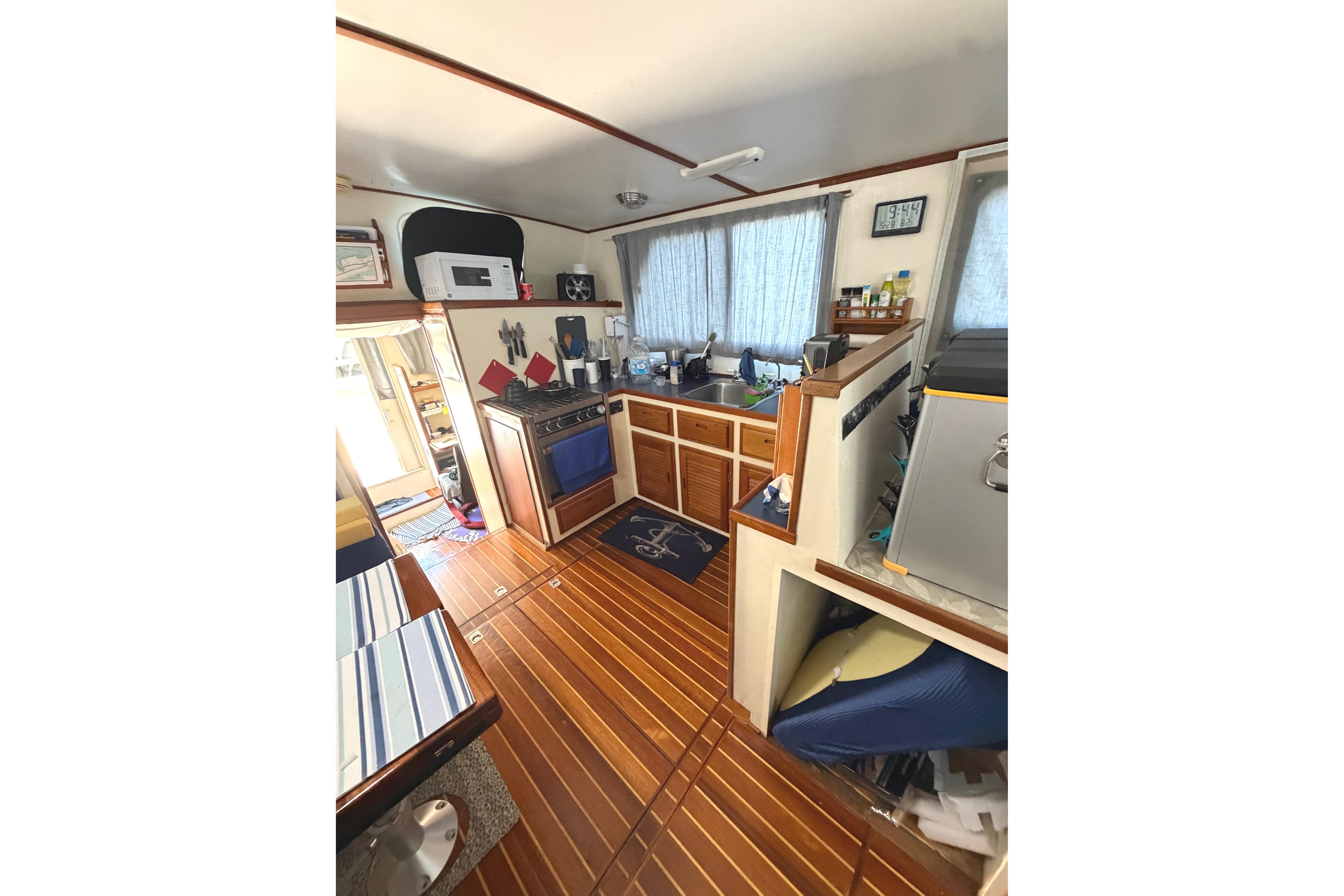 Interior of a 1997 Rosborough Trawler featuring a compact kitchen with wooden flooring.