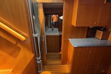 Interior of 2007 Island Pilot 395 yacht with wooden cabinetry and compact kitchen area.