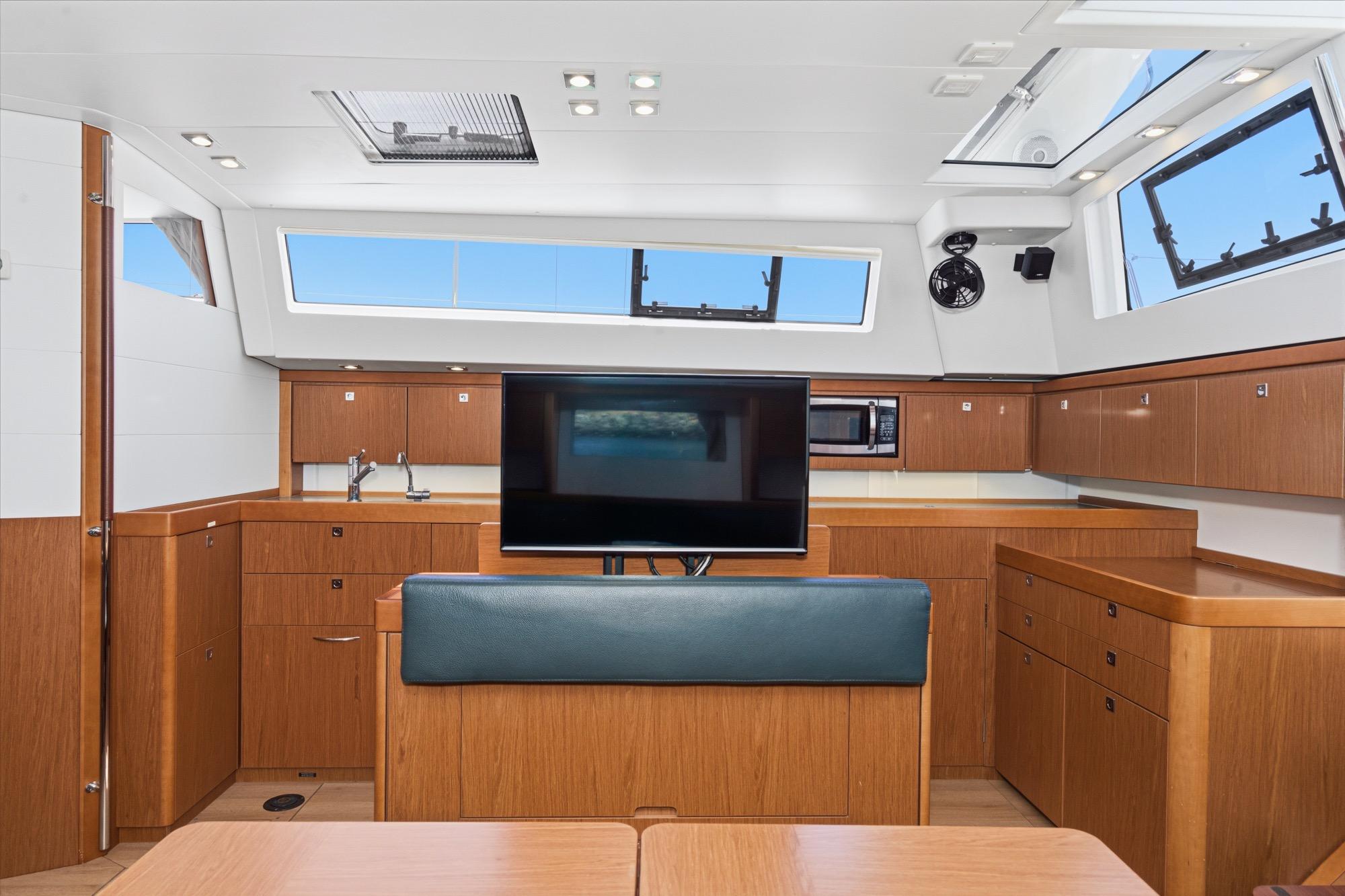 Luxurious interior of 2017 Beneteau Sense 50 yacht with modern kitchen and entertainment area.