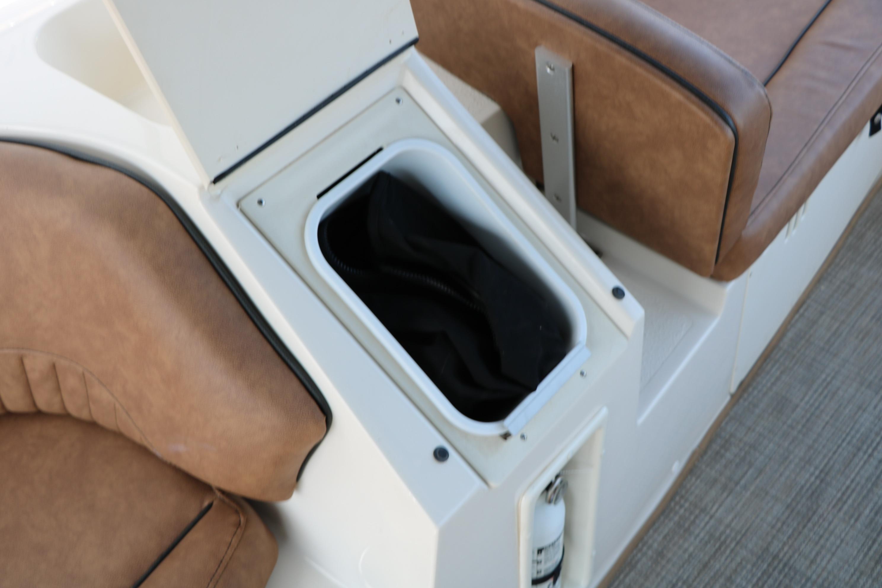 Storage compartment on 2022 Stingray 192 SC boat with brown seating.