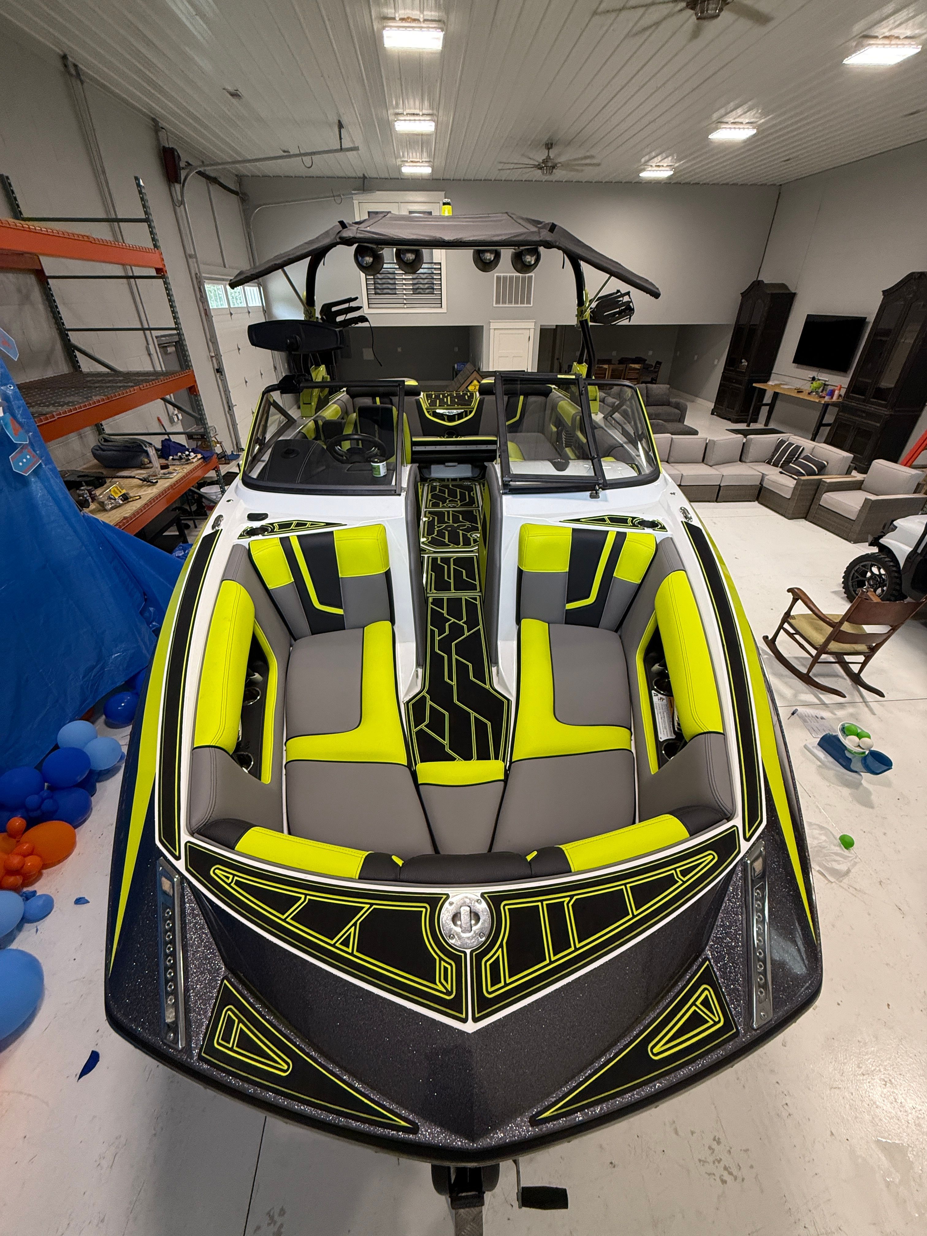 The image shows a 2016 Super Air Nautique G23 boat with bright yellow upholstery in a warehouse.