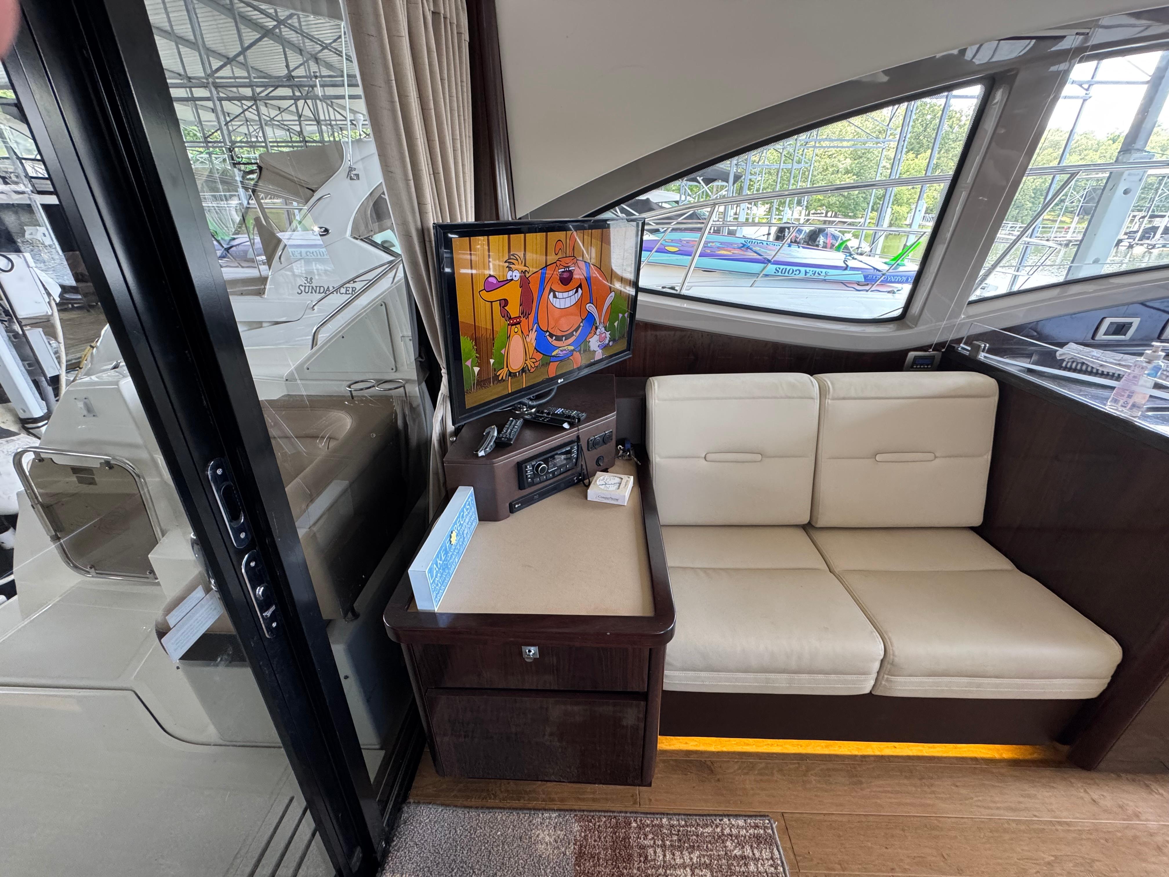 Interior of 2017 Sea Ray Sundancer 400 with TV and white seating area.