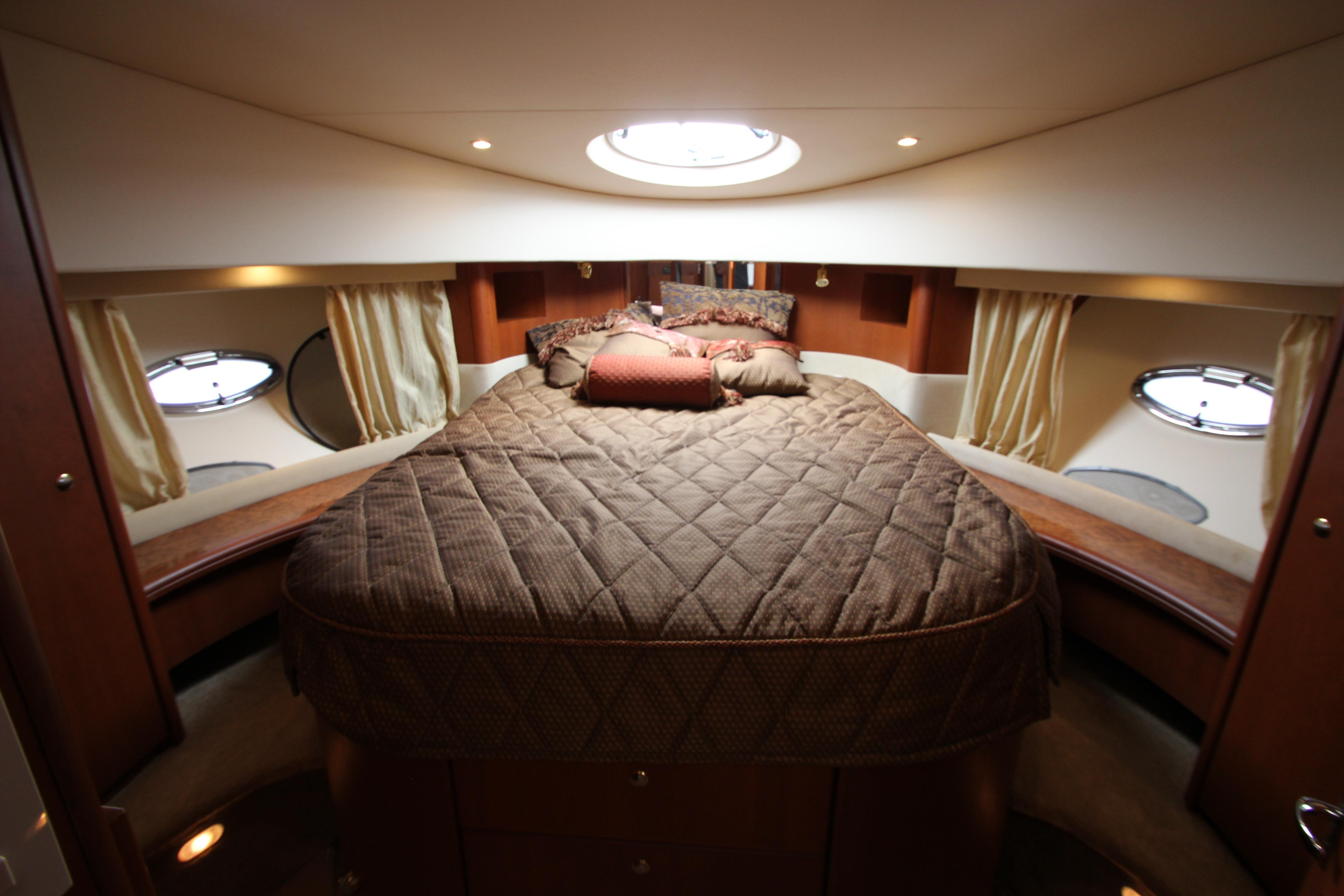 Luxurious cabin interior of 2006 Silverton 38 Sport Bridge yacht with cozy bedding.
