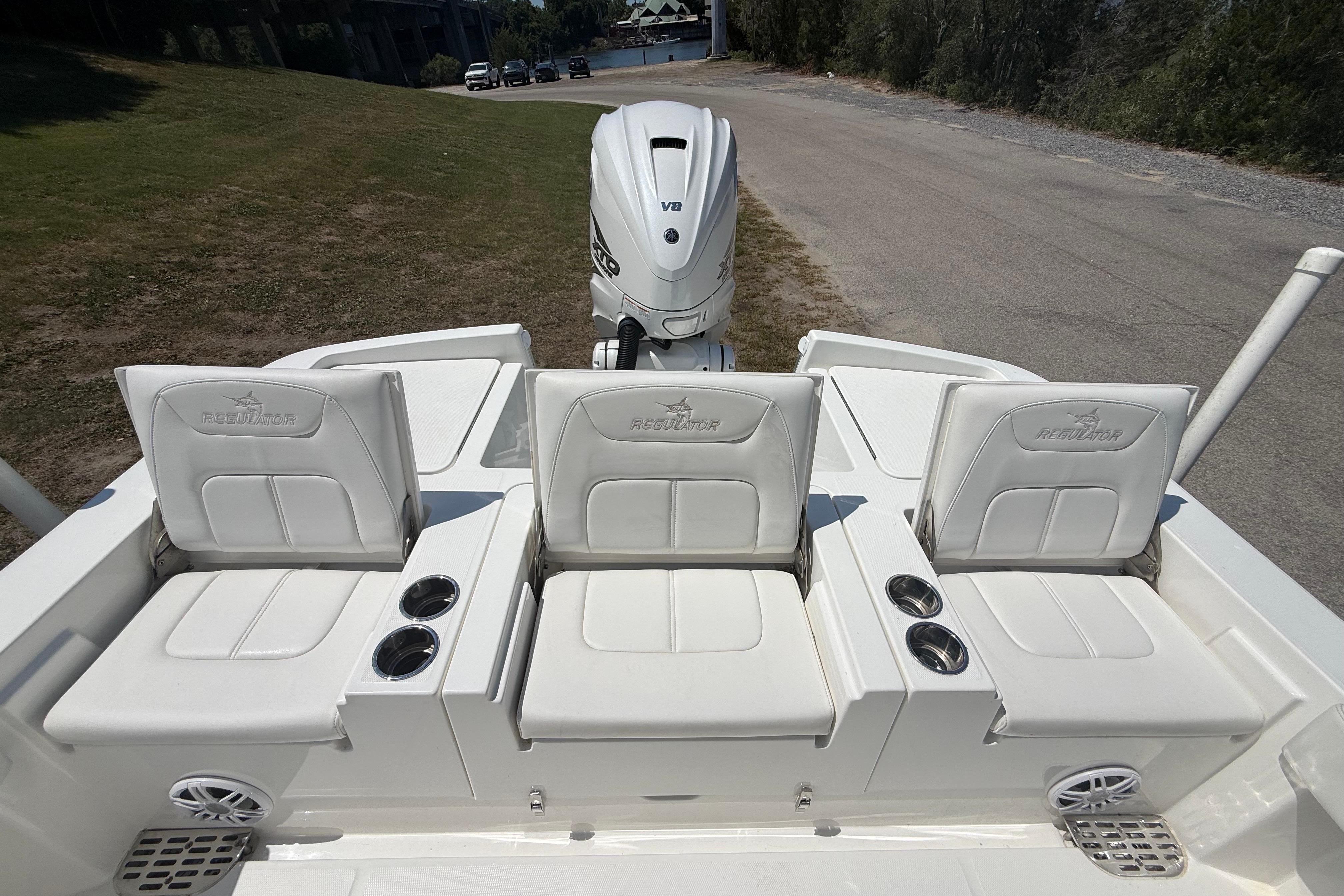 2023 Regulator 26XO boat with three white cushioned seats and Yamaha V6 engine.