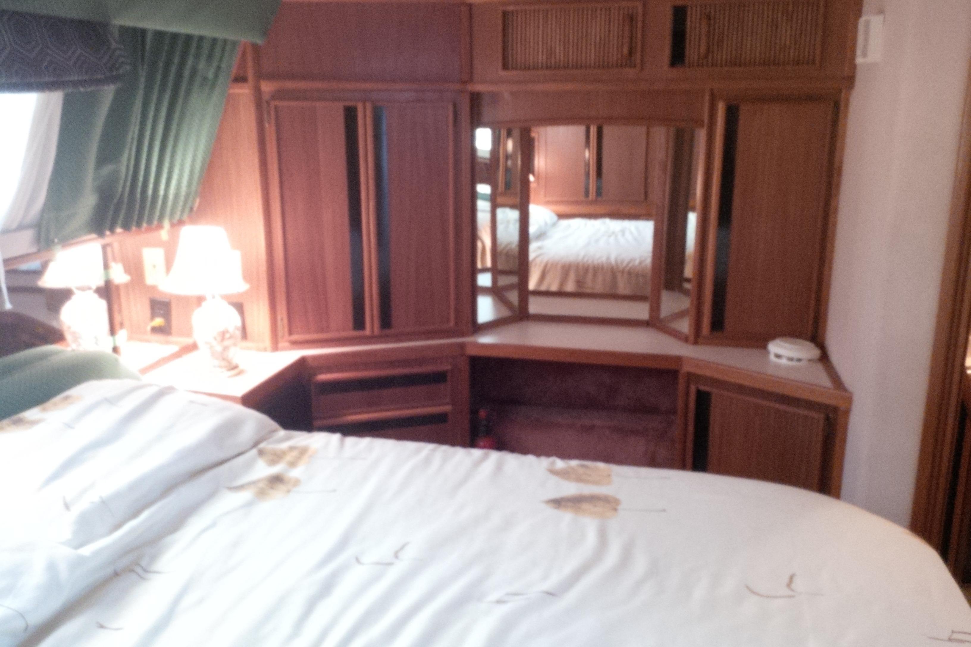 1988 Sea Ray 415 Aft Cabin bedroom with wood cabinetry and cozy decor.