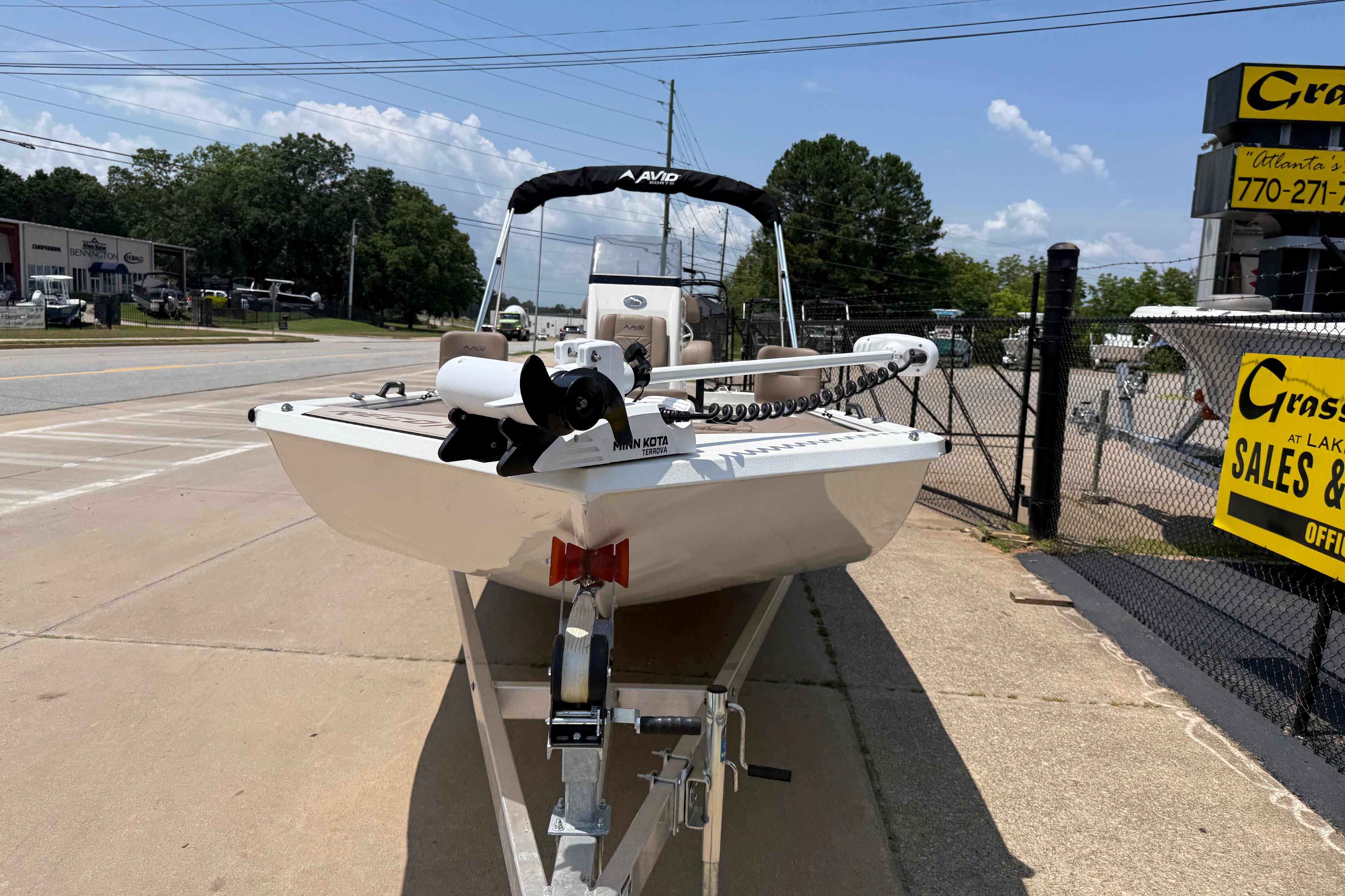 2025 Avid 22 Recon boat on trailer at dealership, sunny day.