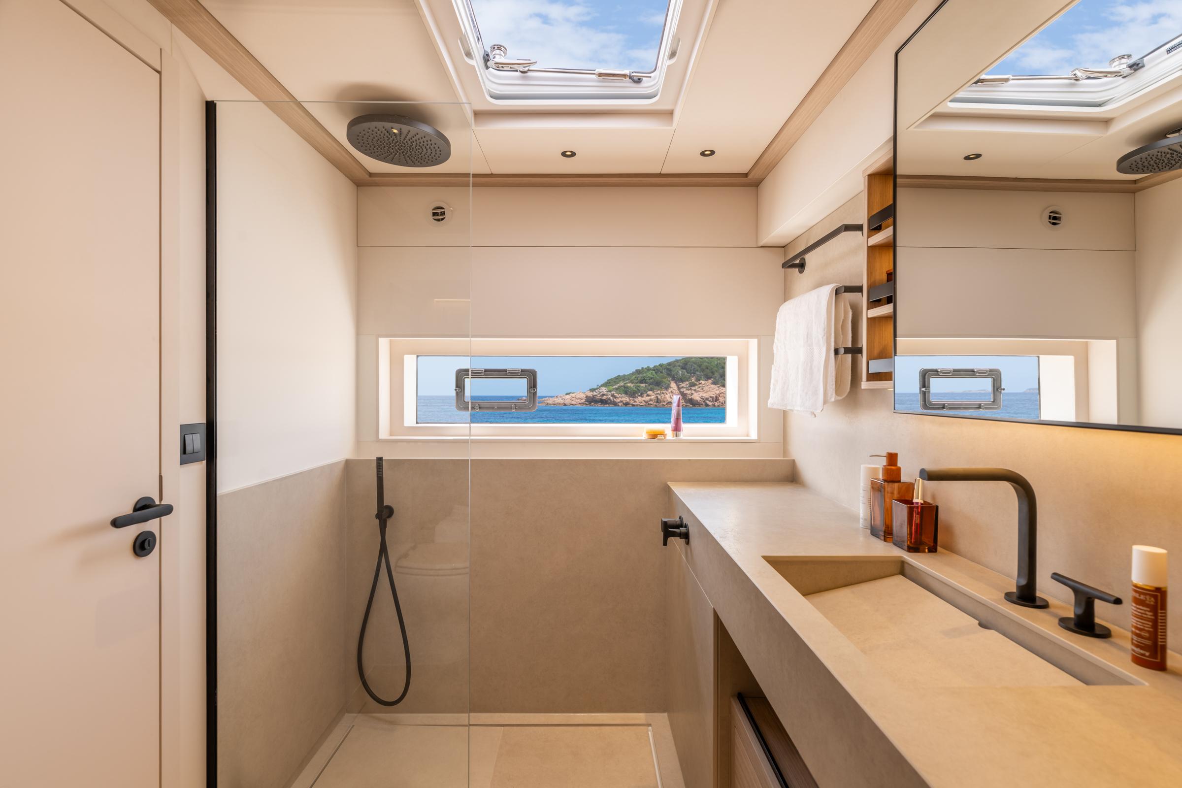 Luxurious bathroom on 2025 Lagoon Eighty 2 yacht with ocean view and modern fixtures.
