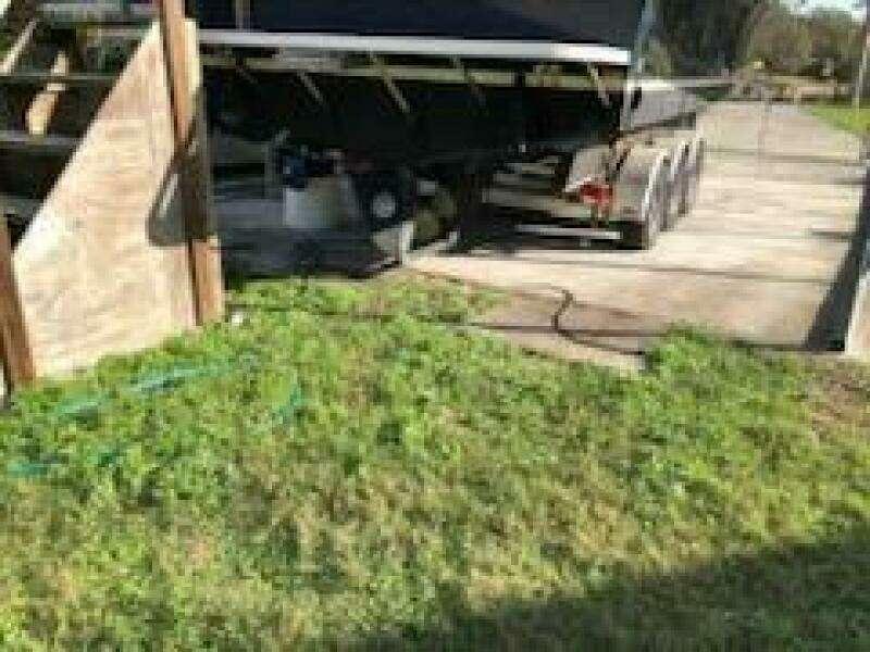 Trailer with 1995 Albin 28 Tournament boat parked on concrete driveway.