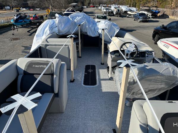 2025 Harris Cruiser 230 pontoon boat interior with protective covers, parked outdoors.
