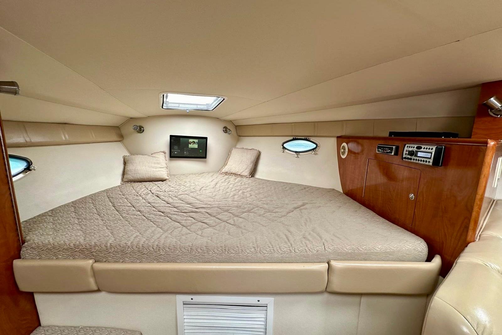 2007 Larson Cabrio 330 Day Cruiser cabin with cozy bed and modern amenities.