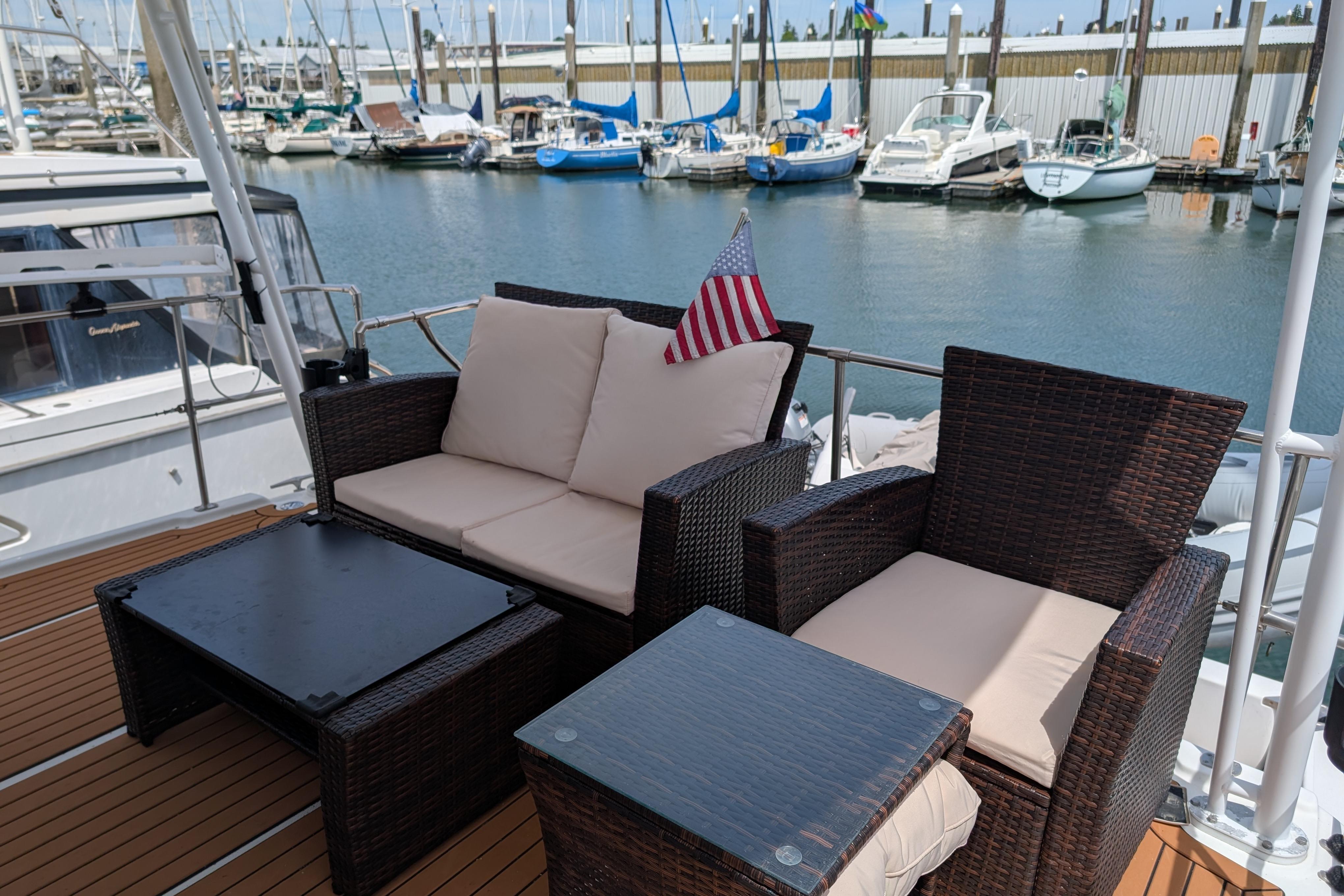 Outdoor seating on 2000 Bayliner 4088 yacht, docked at marina with boats in background.