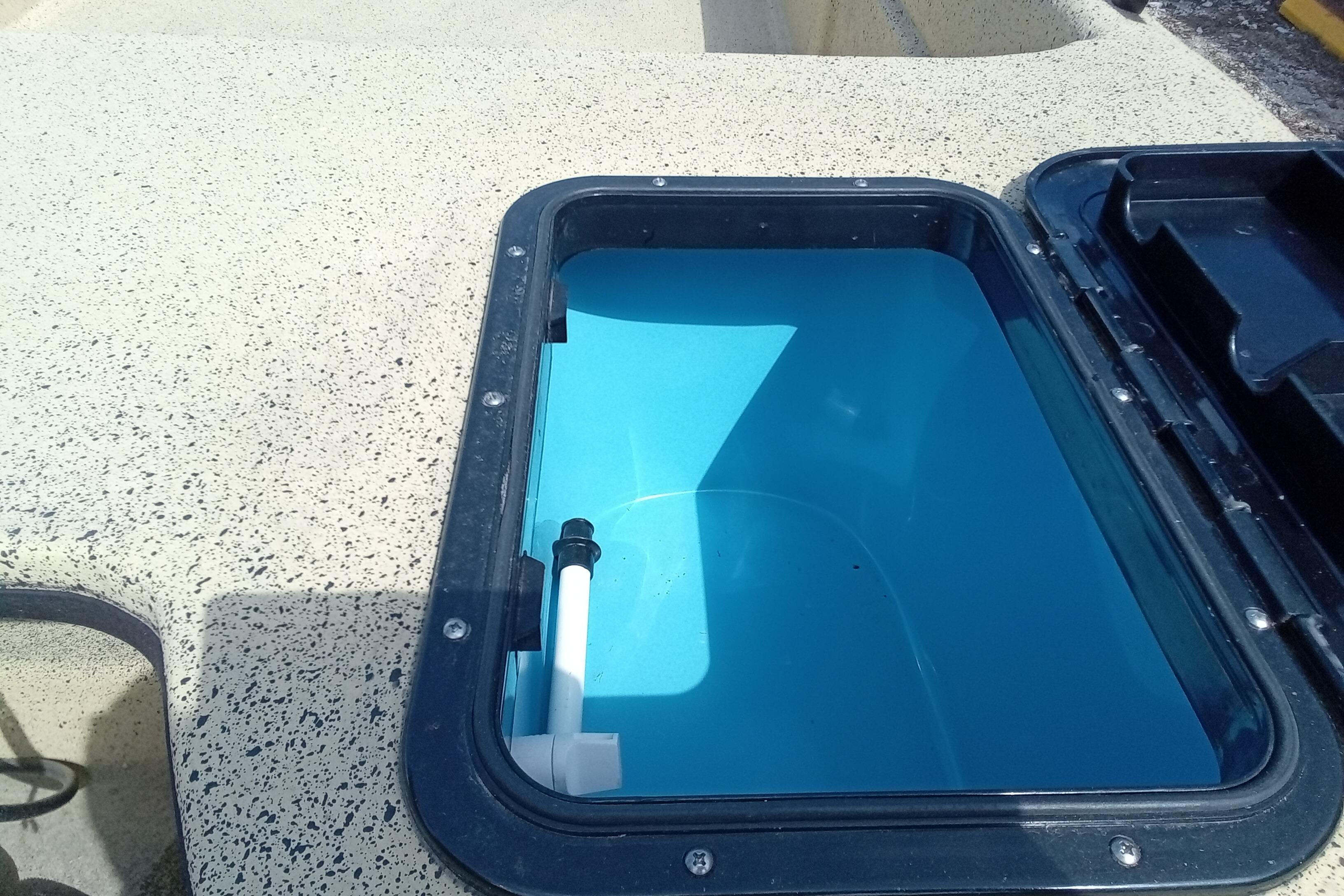 Open hatch on Fibercraft F17 boat, 2025 model, showing interior compartment.