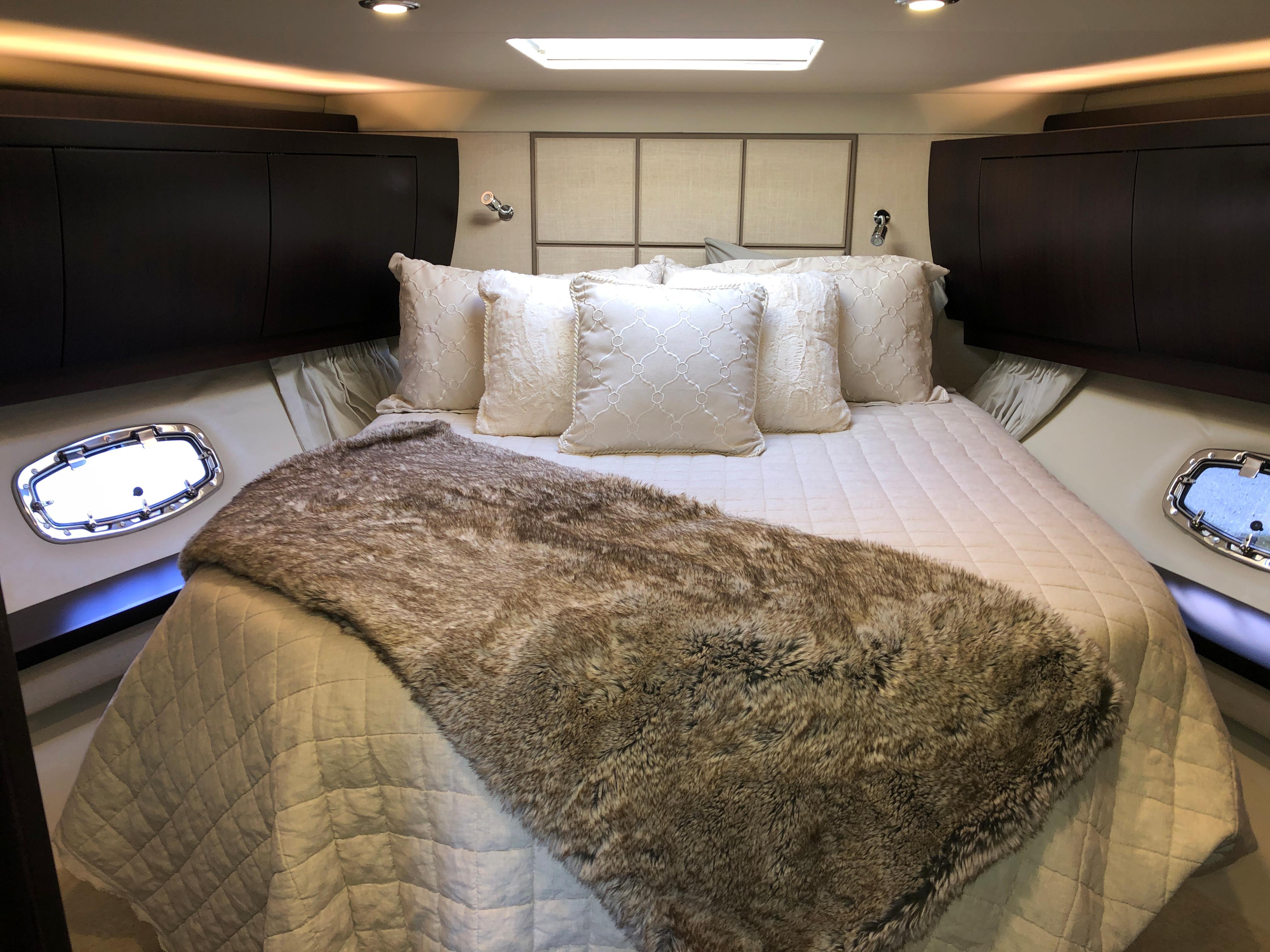 Luxurious bedroom interior of 2017 Regal 53 Sport Coupe yacht with plush bedding.