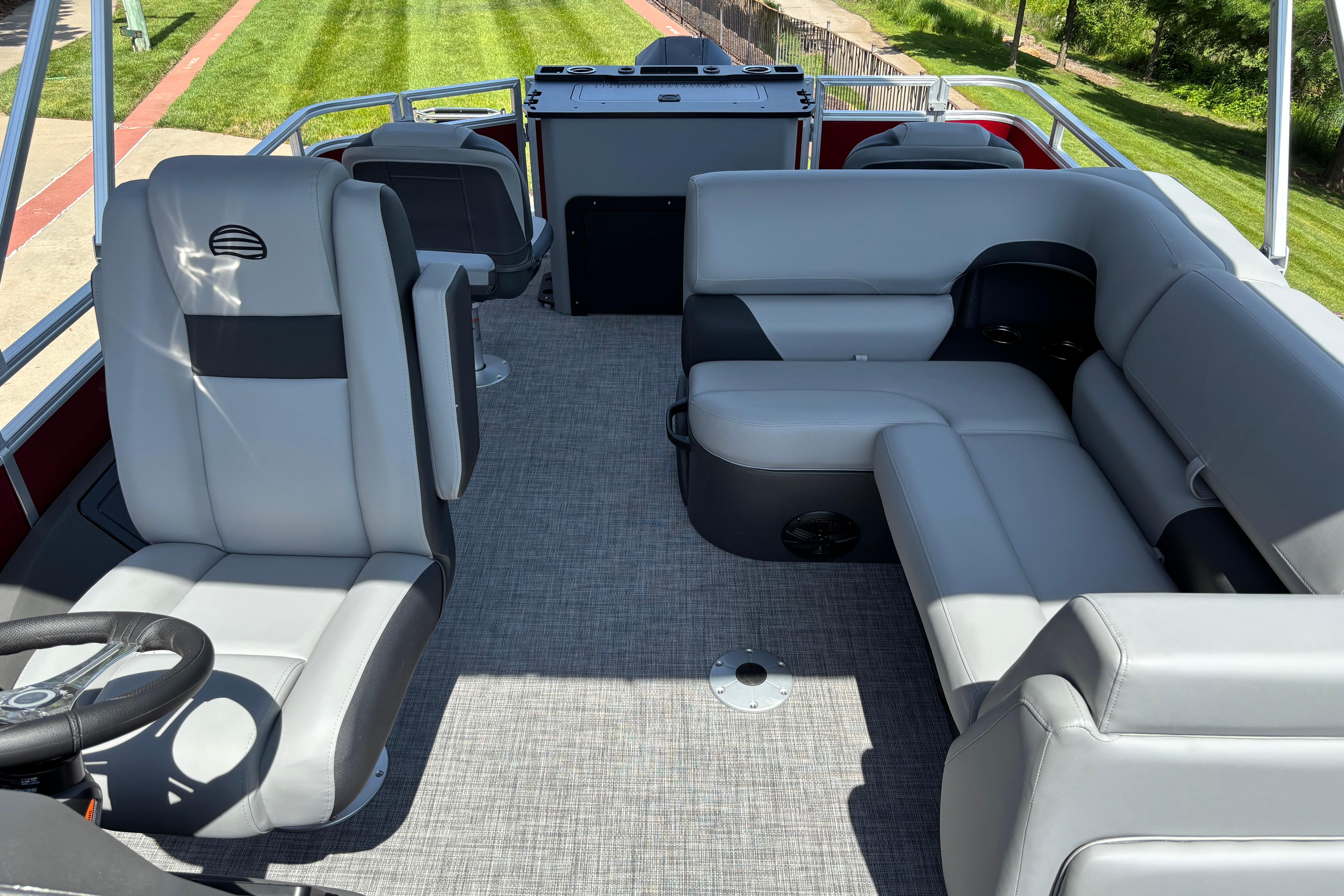 2026 Sun Tracker SportFish 22 XP3 interior with gray seating and steering wheel.