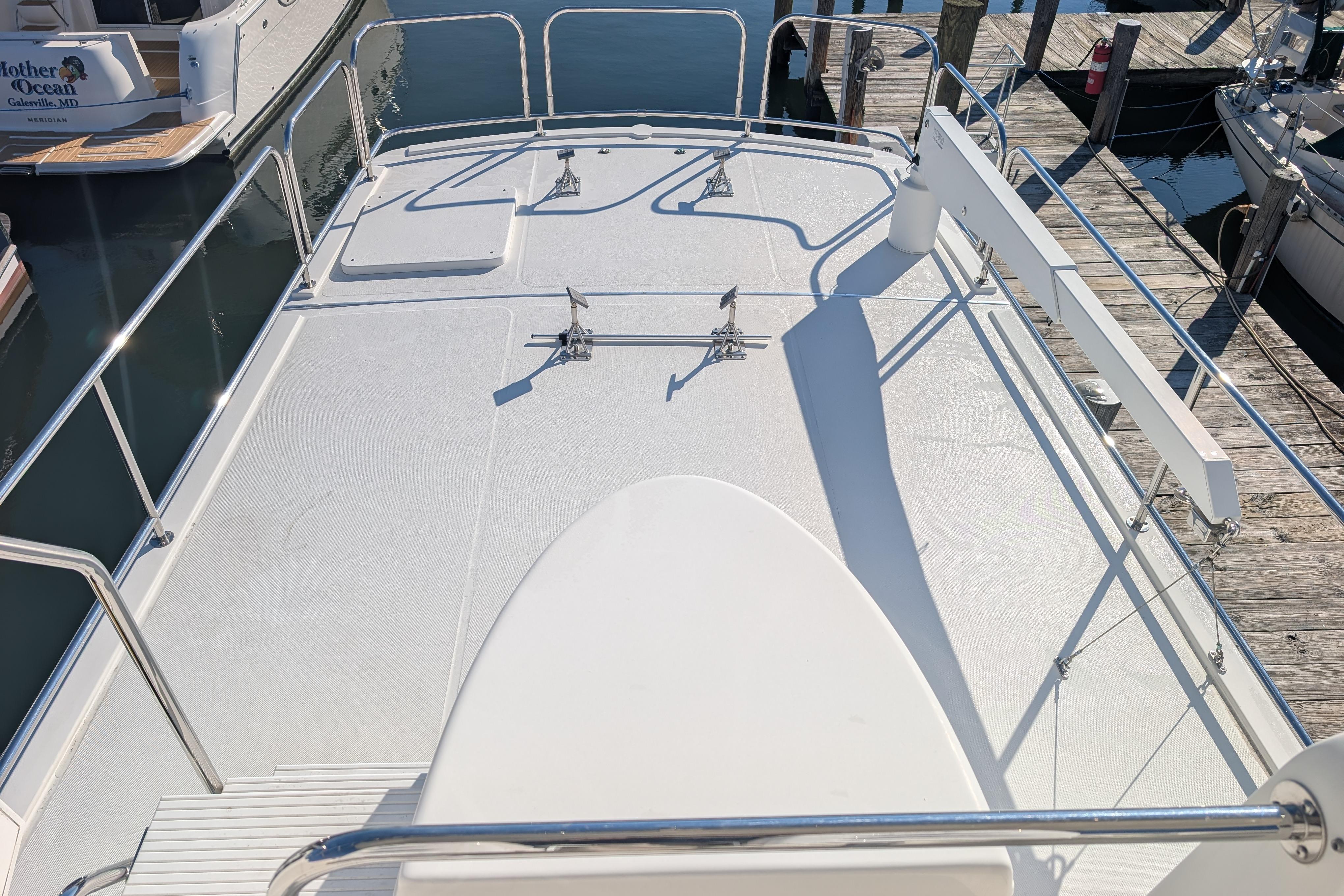 American Tug 435 (2015) boat deck with railings, docked at marina.