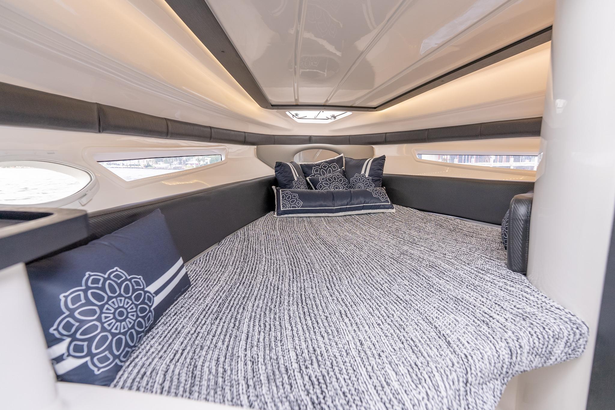 Luxurious interior cabin of 2027 Hanover 305 boat with elegant bedding and ambient lighting.