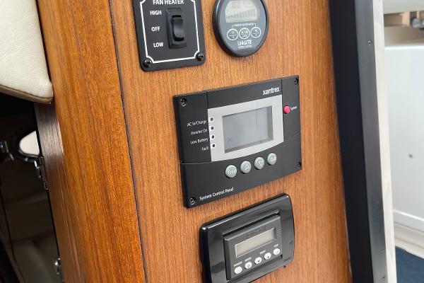 Electronics panel with various controls and displays on wood paneling.