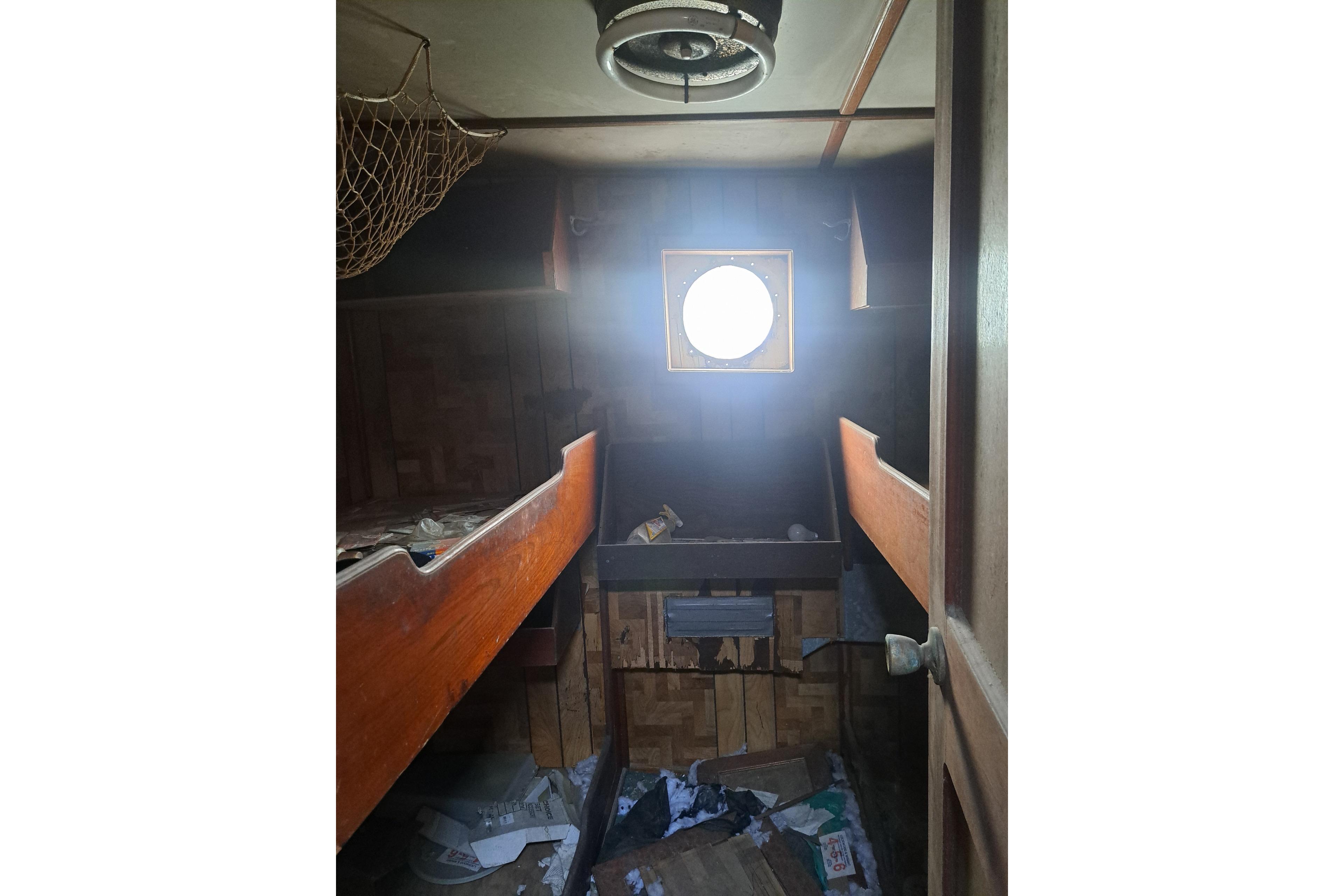 Interior of 1979 Custom Steel Trawler Dragger with bunks and porthole window.