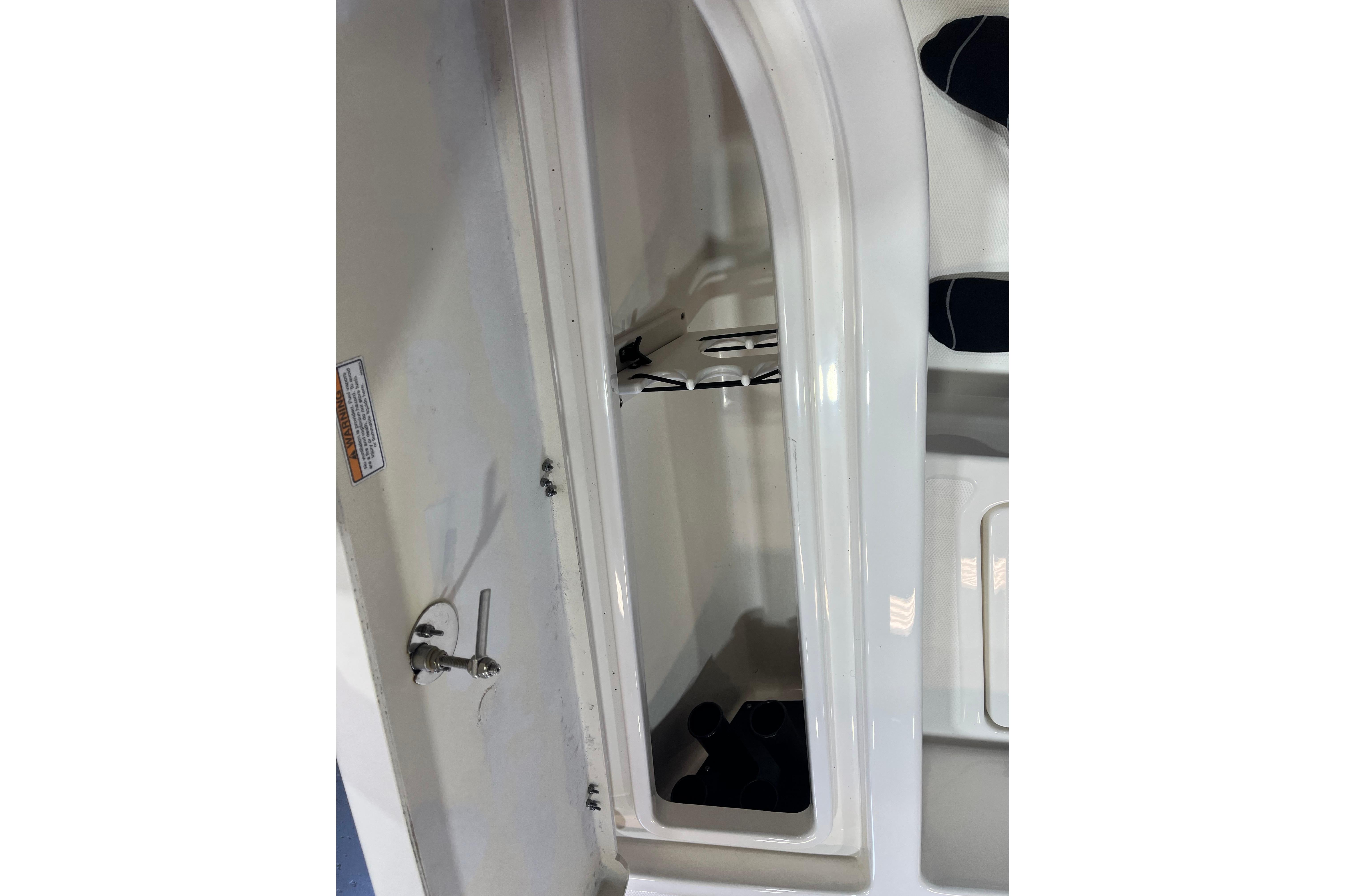 2023 NauticStar 227 XTS boat storage compartment with latch and interior view.