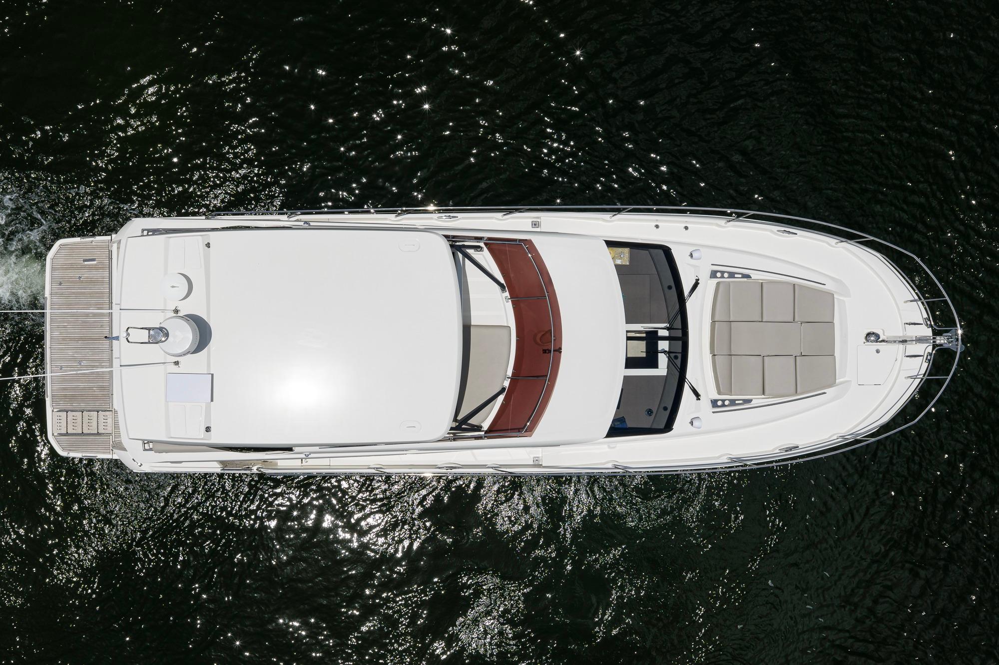 Top view of a 2021 Prestige 520 yacht on water, showcasing sleek design and spacious deck.