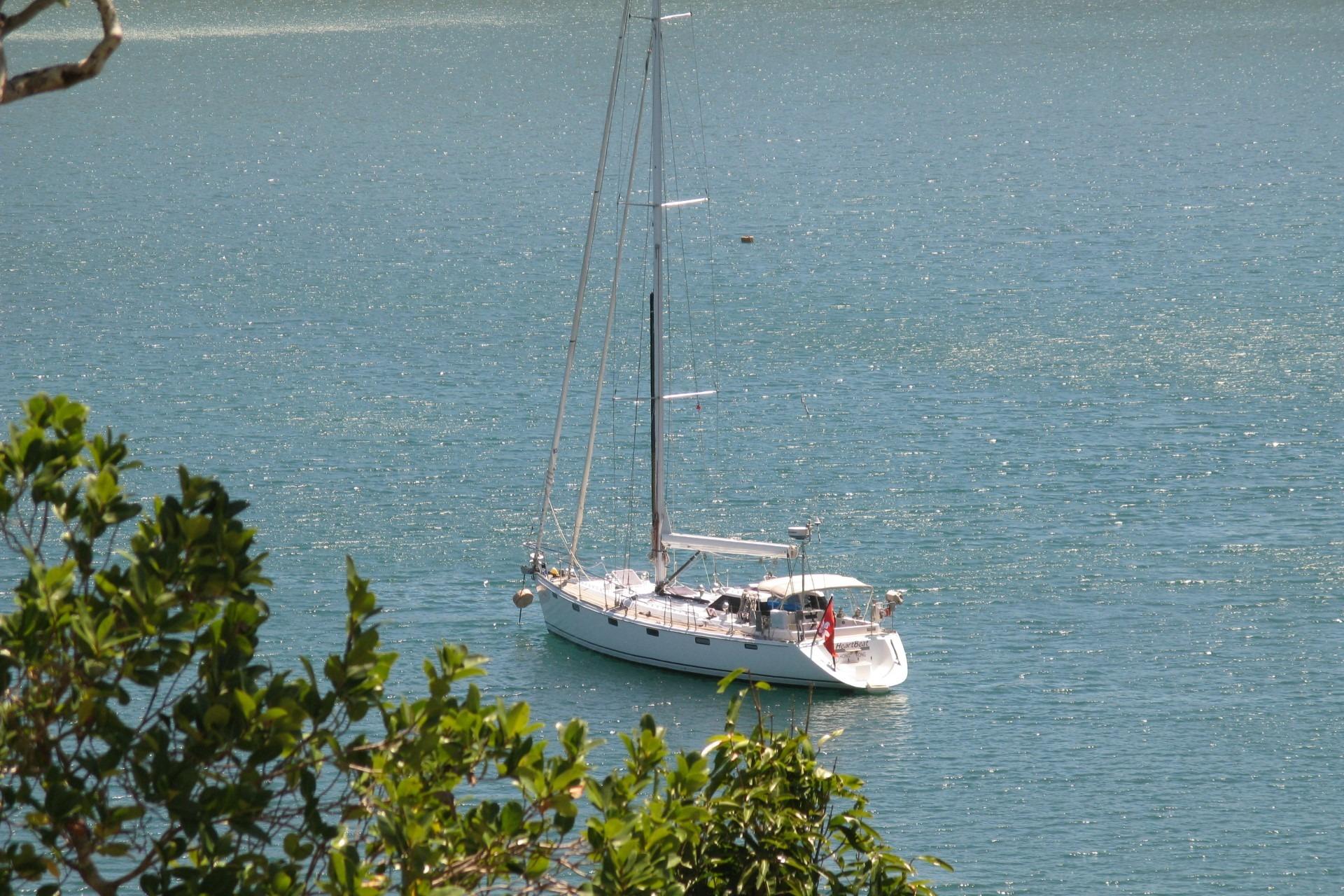 Sailing yacht McConaghy Bermuda 52 (1998) anchored in tranquil blue waters.