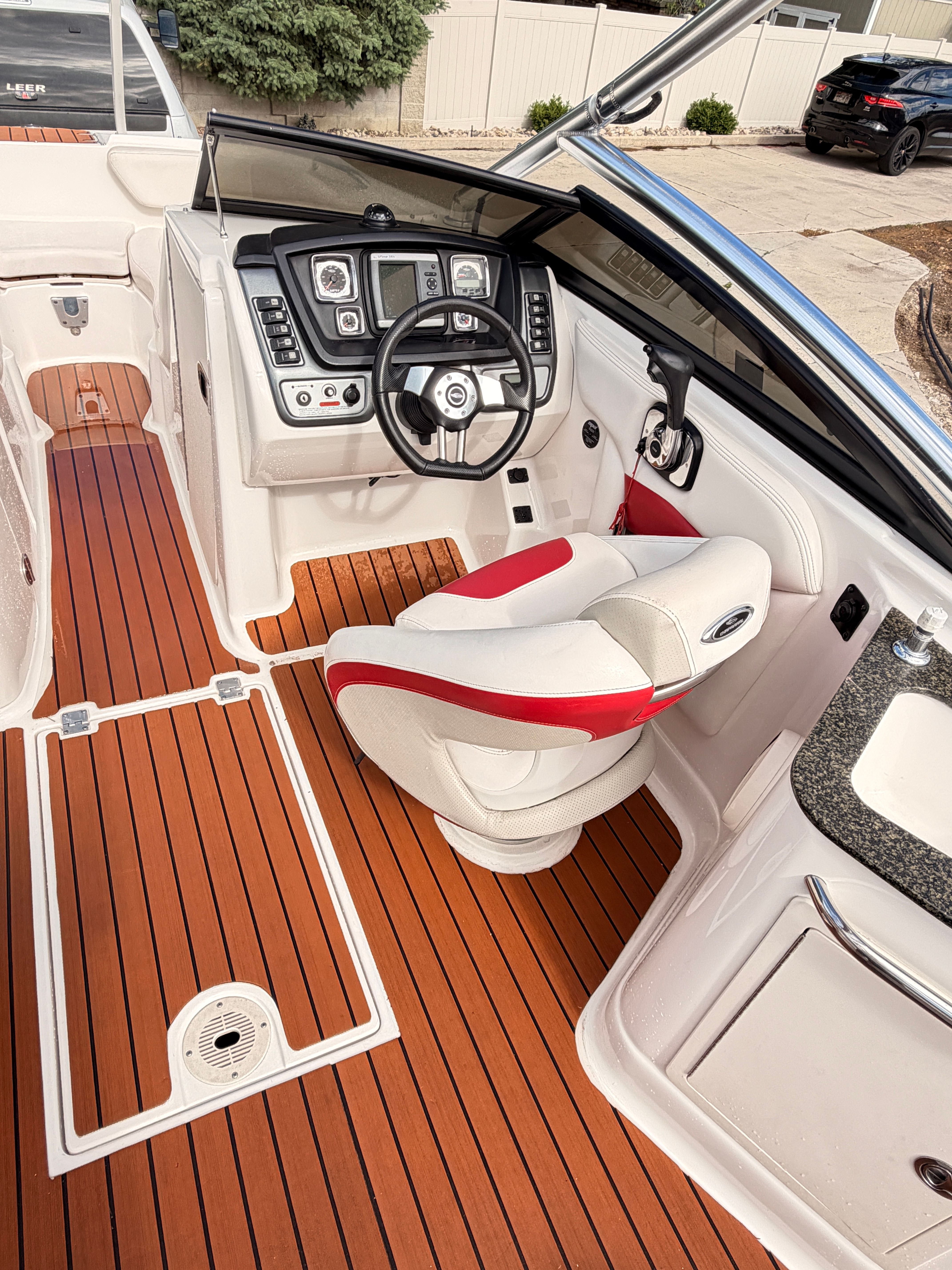 The image shows the cockpit of a 2008 Chaparral Sunesta 224 with a sleek helm and wood flooring.