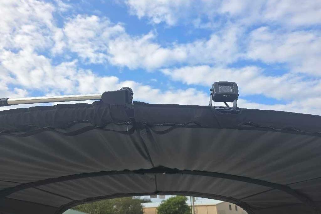 Regency 250 LE3 Sport 2025 boat canopy with camera under blue sky.