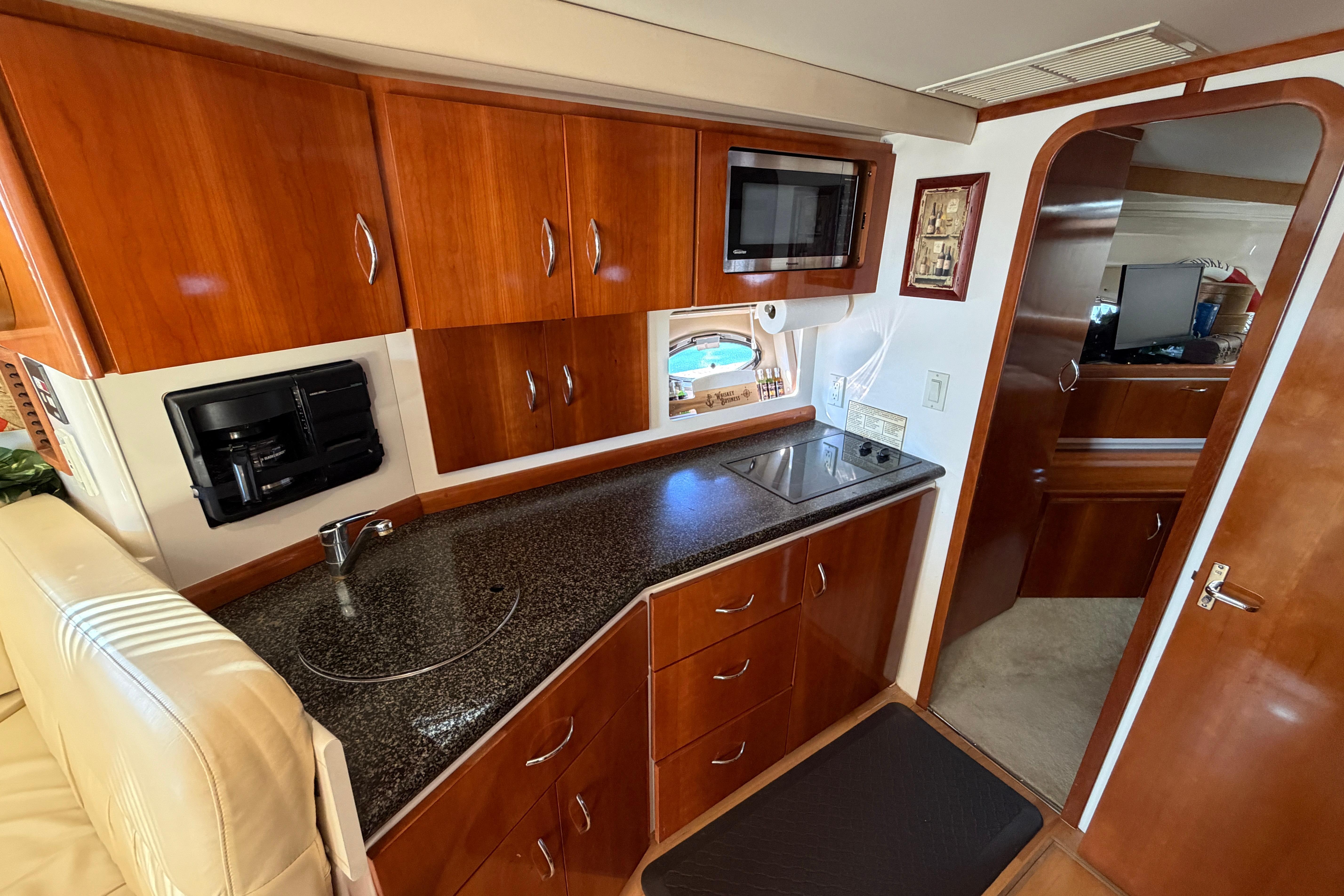 Luxurious 2003 Carver 350 Mariner yacht interior with modern kitchen amenities and wood cabinetry.