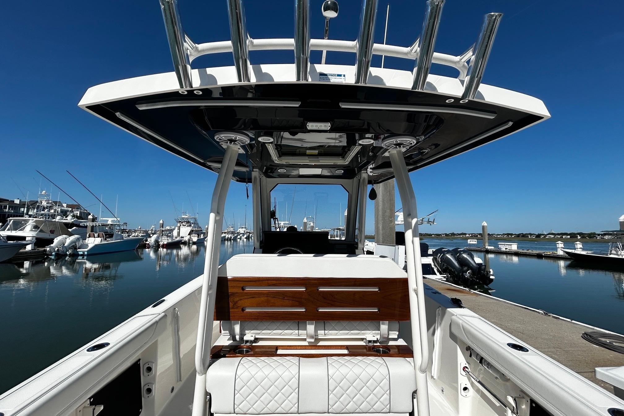 2024 Pursuit S 288 Sport boat docked at marina, showcasing sleek design and luxury seating.