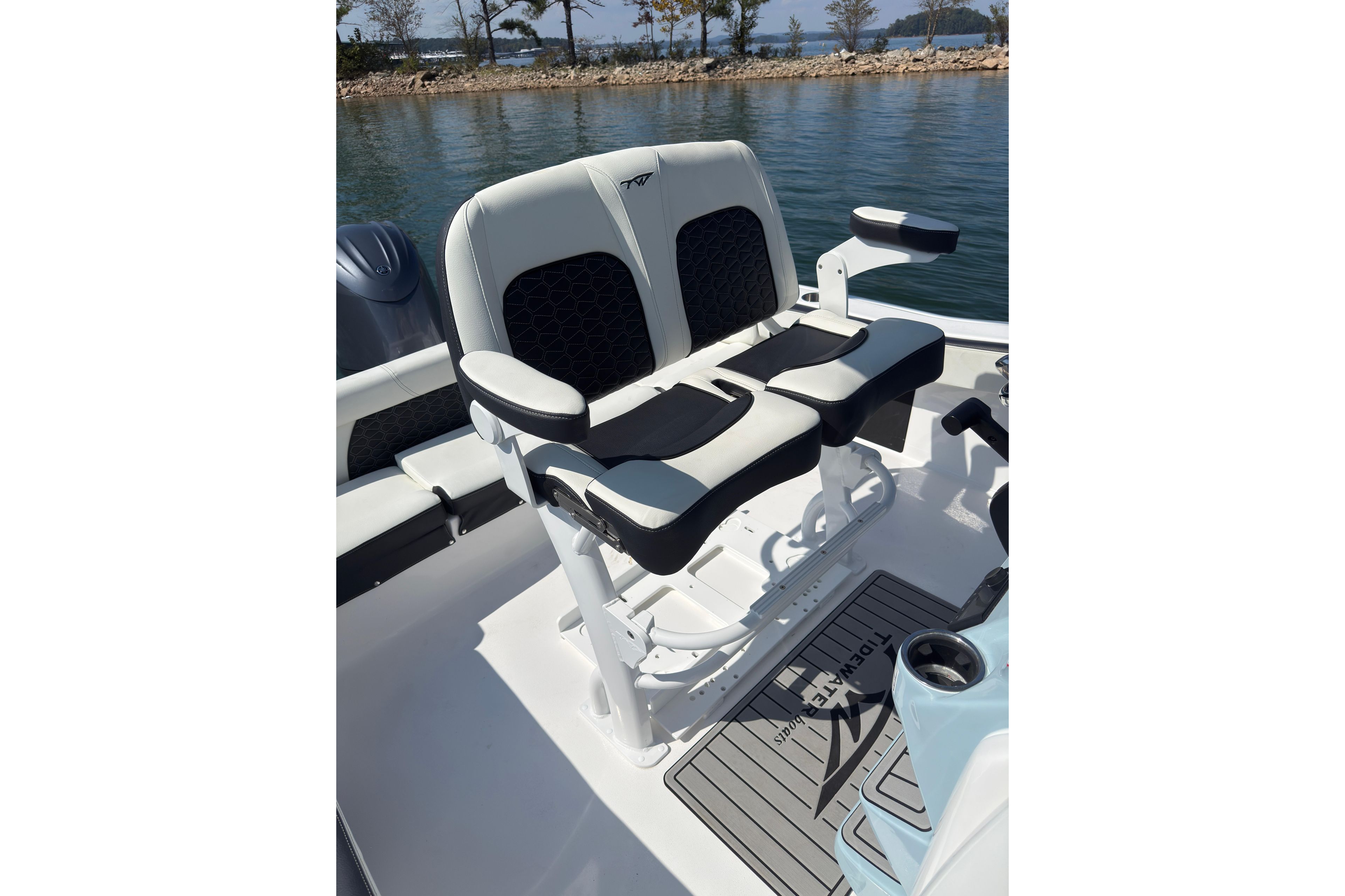 2026 Tidewater 220 LXF boat seating, featuring dual cushioned seats with armrests, on calm water.
