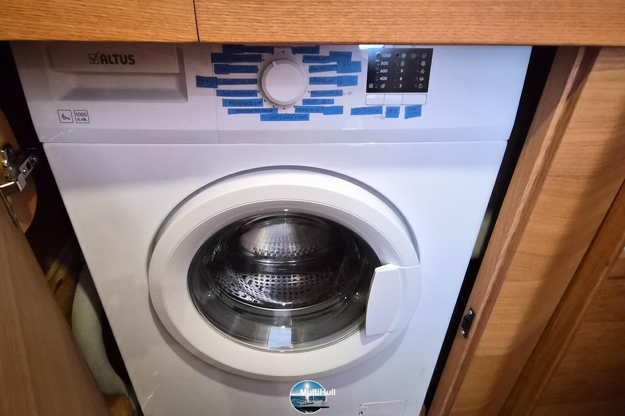 Washing machine inside Catana 50 yacht, 2007 model, with wooden cabinetry.
