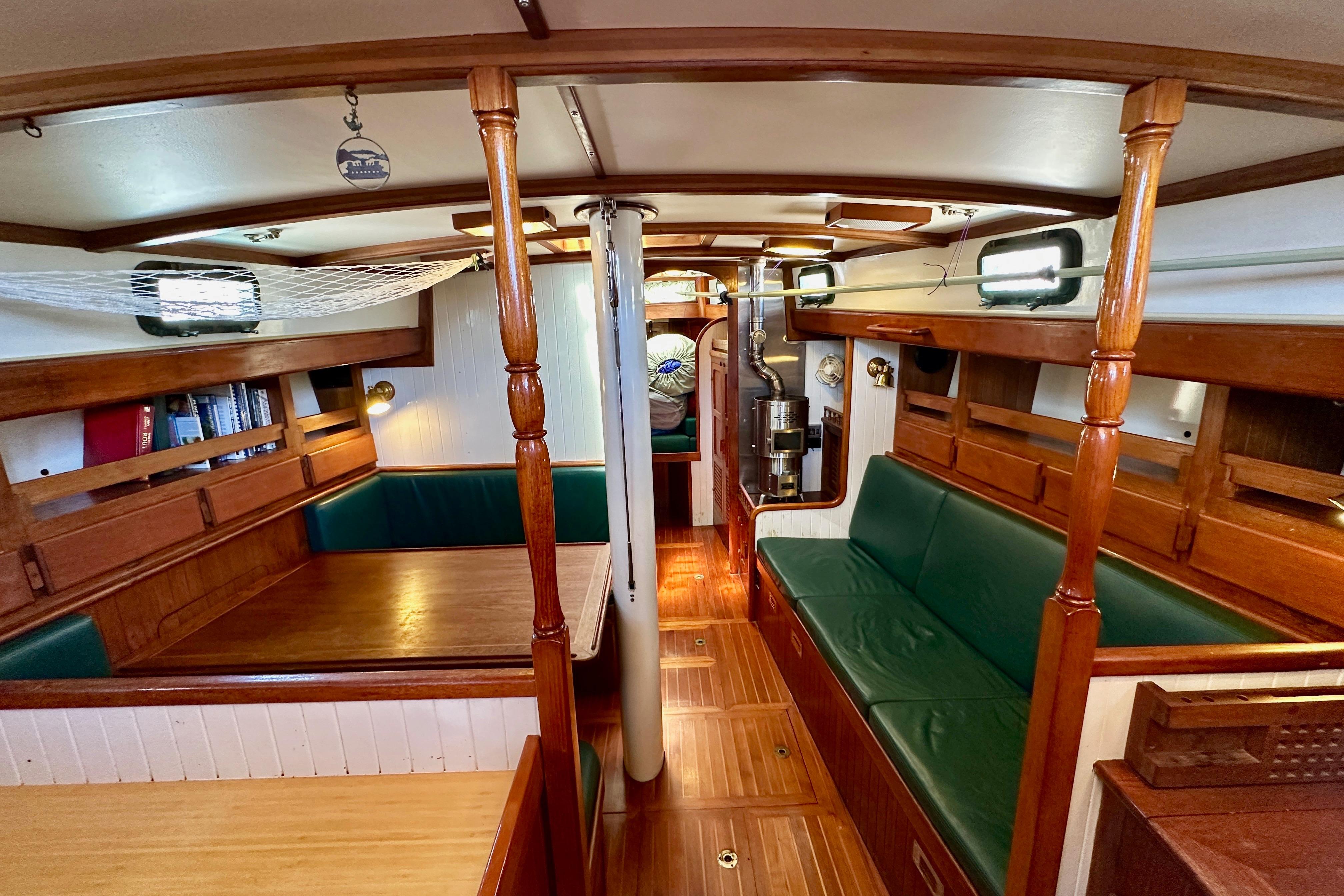 Interior of 1981 Kelly Peterson 46 sailboat with wooden furnishings and green seating.
