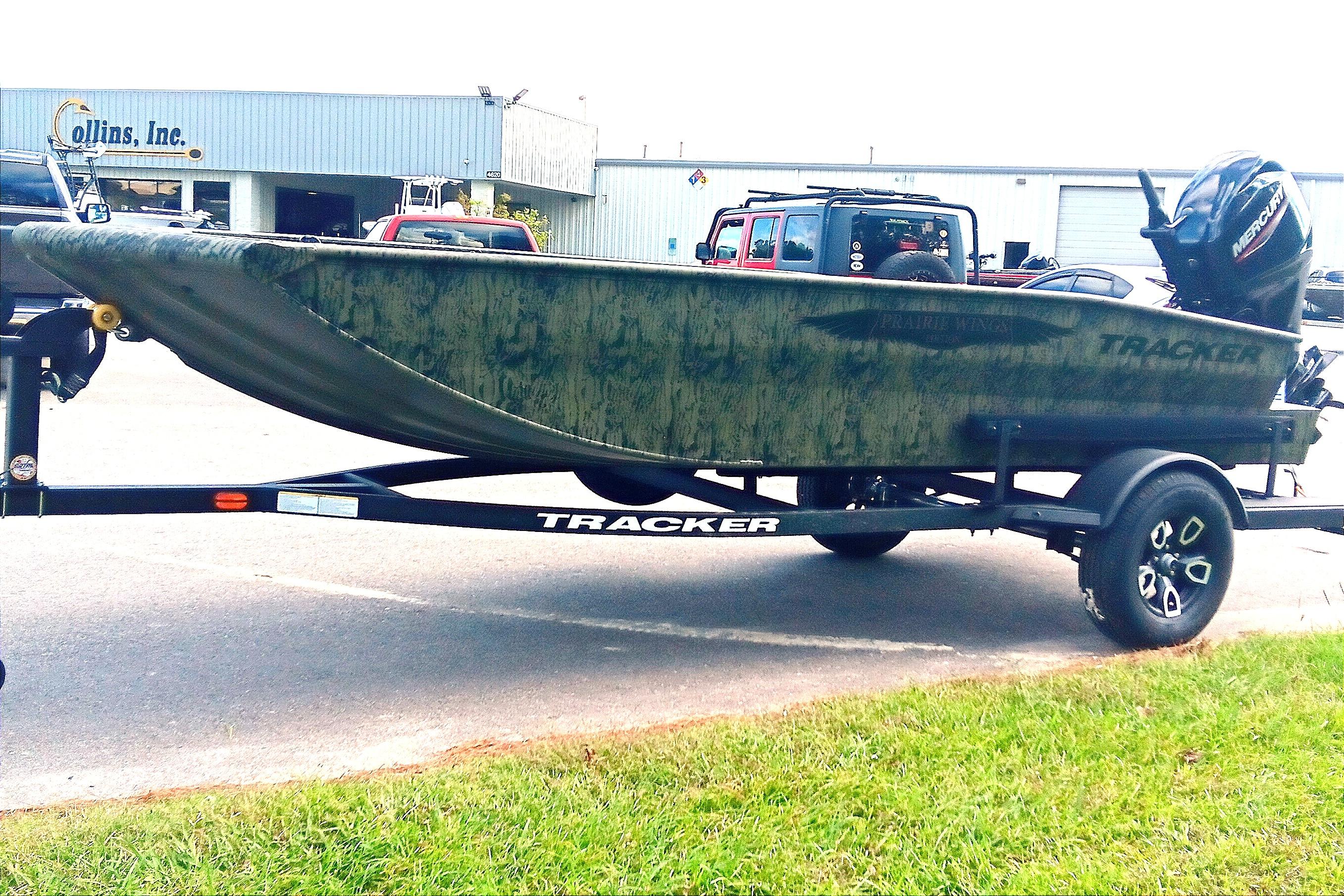 2026 Tracker Grizzly 1650 T Prairie Wings Edition boat on trailer, parked outdoors.