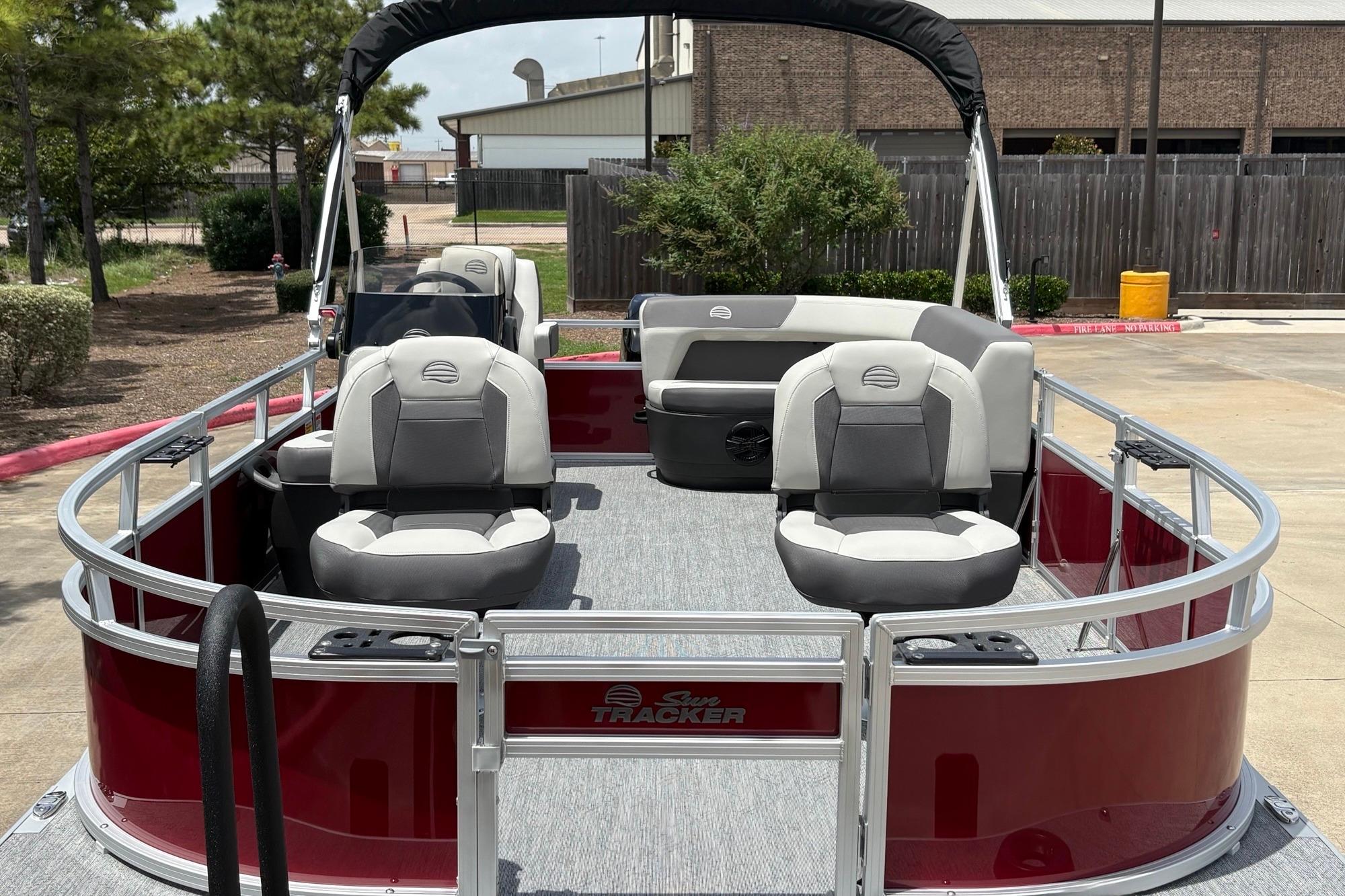 2026 Sun Tracker Bass Buggy 16 XL Select pontoon boat with seating, docked outdoors.
