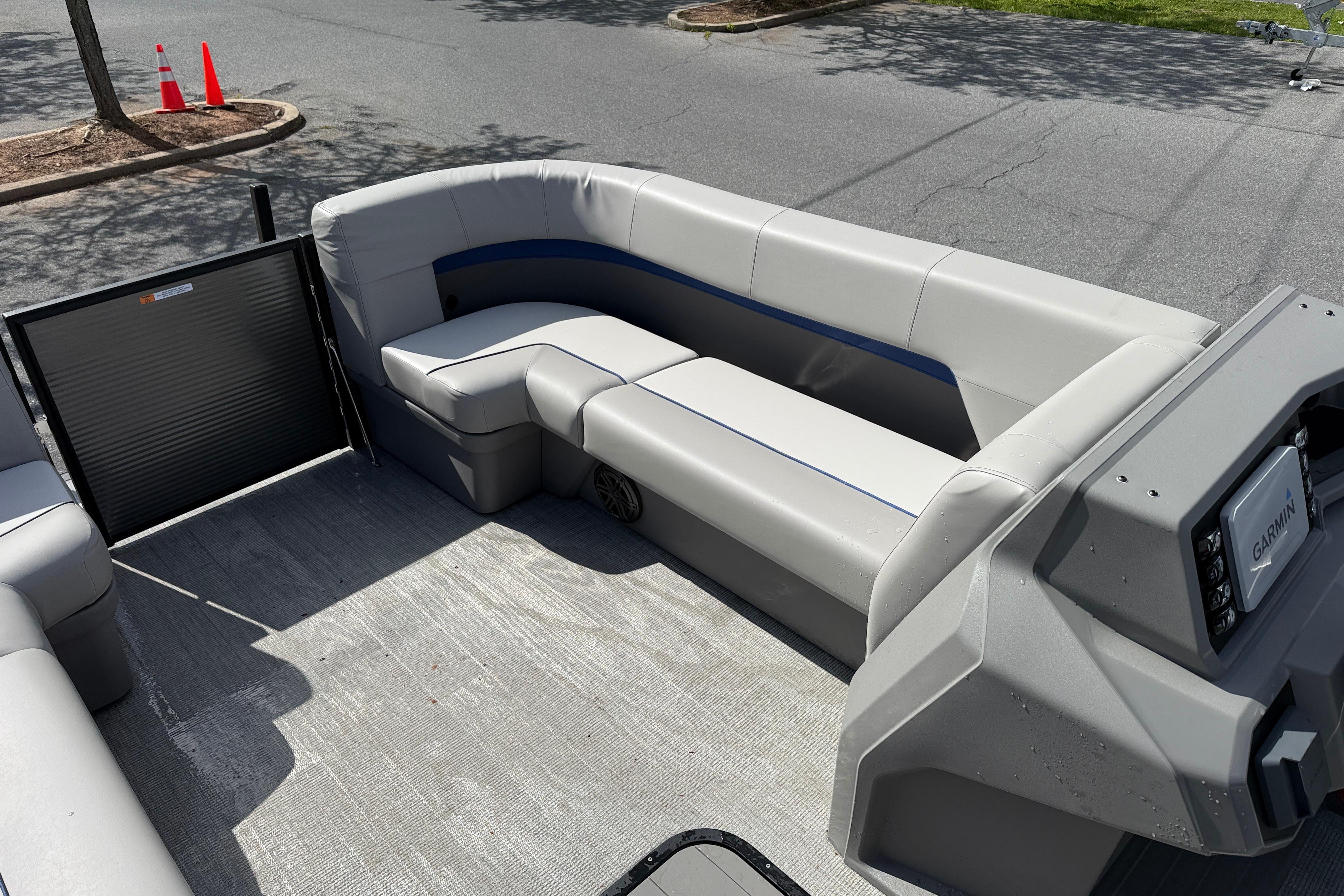 2025 Qwest Splash Pad E-Class boat interior with gray seating and Garmin navigation system.