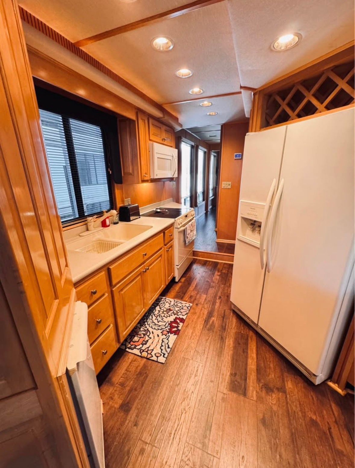 Interior of a 1998 Stardust Cruisers houseboat kitchen with wooden flooring.