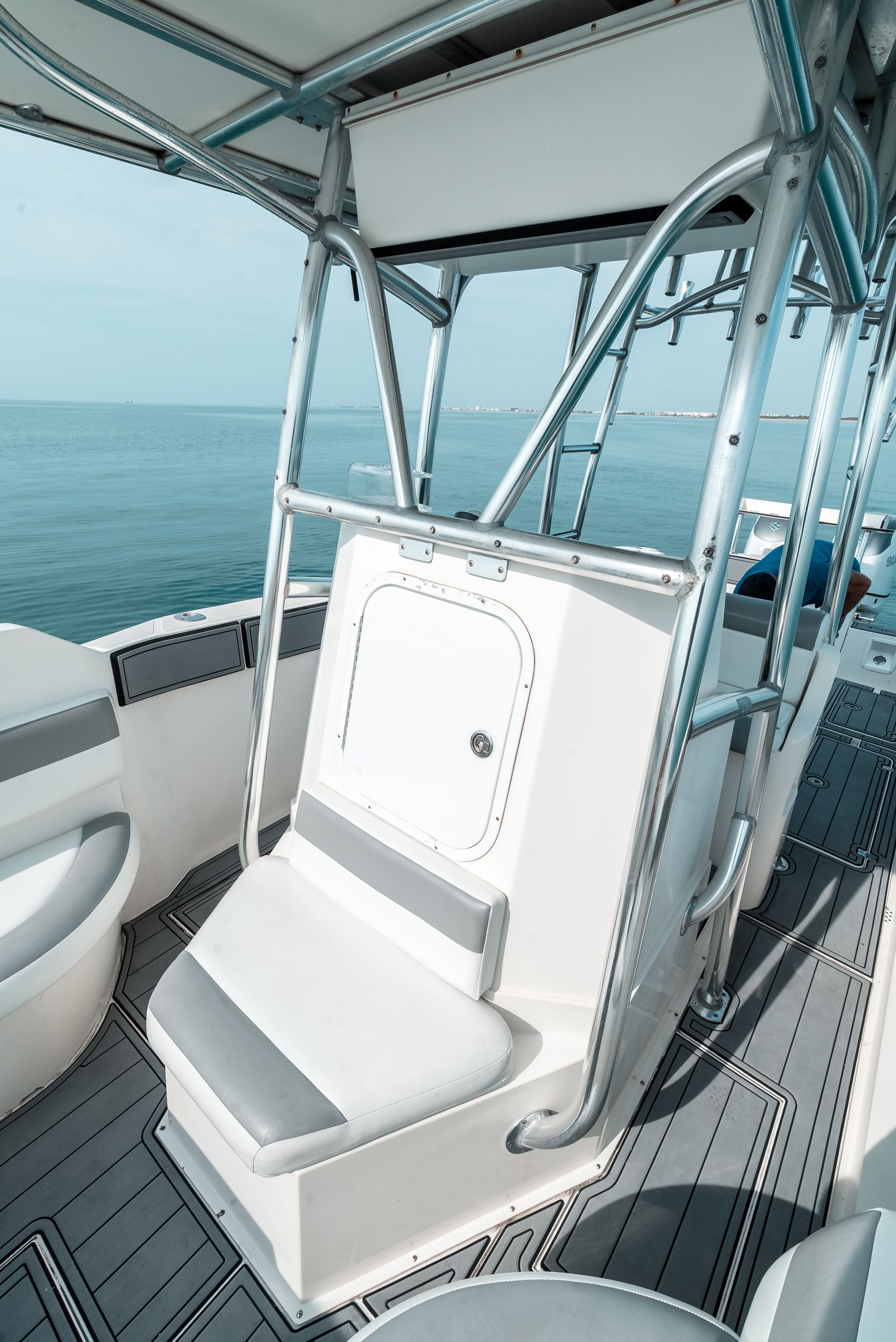 A modern boat with a sturdy seat and metal frame, on calm water.
