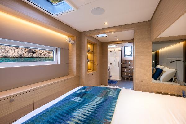 Luxurious interior of 2025 Lagoon 60 yacht cabin with modern design and scenic window view.