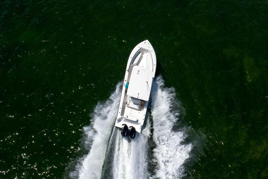 Aerial view of 2027 Reef Runner 340 boat speeding on green water.