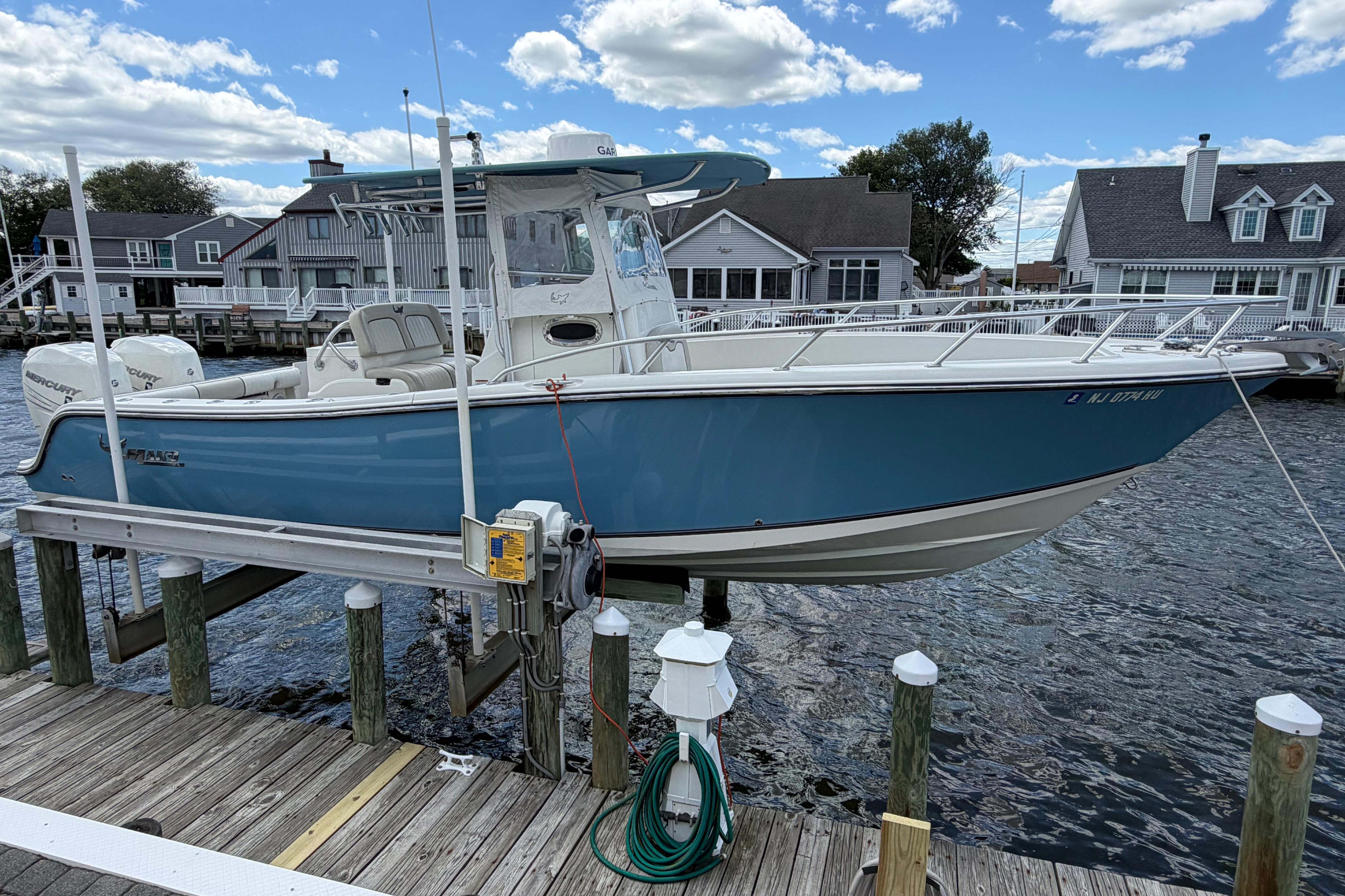 2017 Mako 284 Center Console boat docked at a marina, under a clear blue sky.