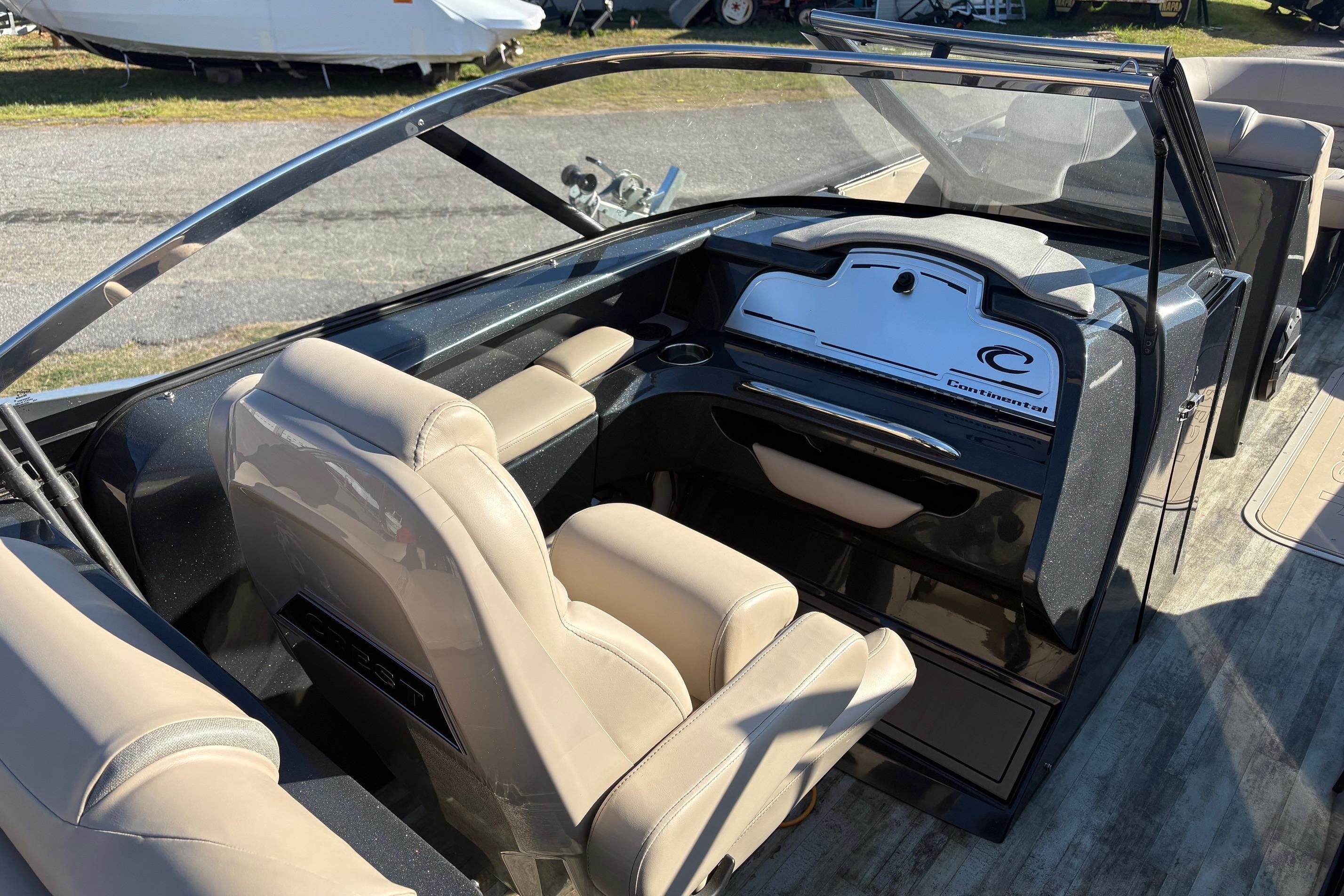Interior of a 2022 Crest Continental 250 boat with beige seating and sleek dashboard design.