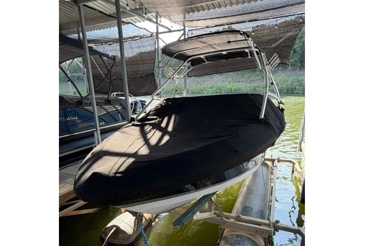 2007 Four Winns 200 Horizon boat covered and docked in a shaded area.