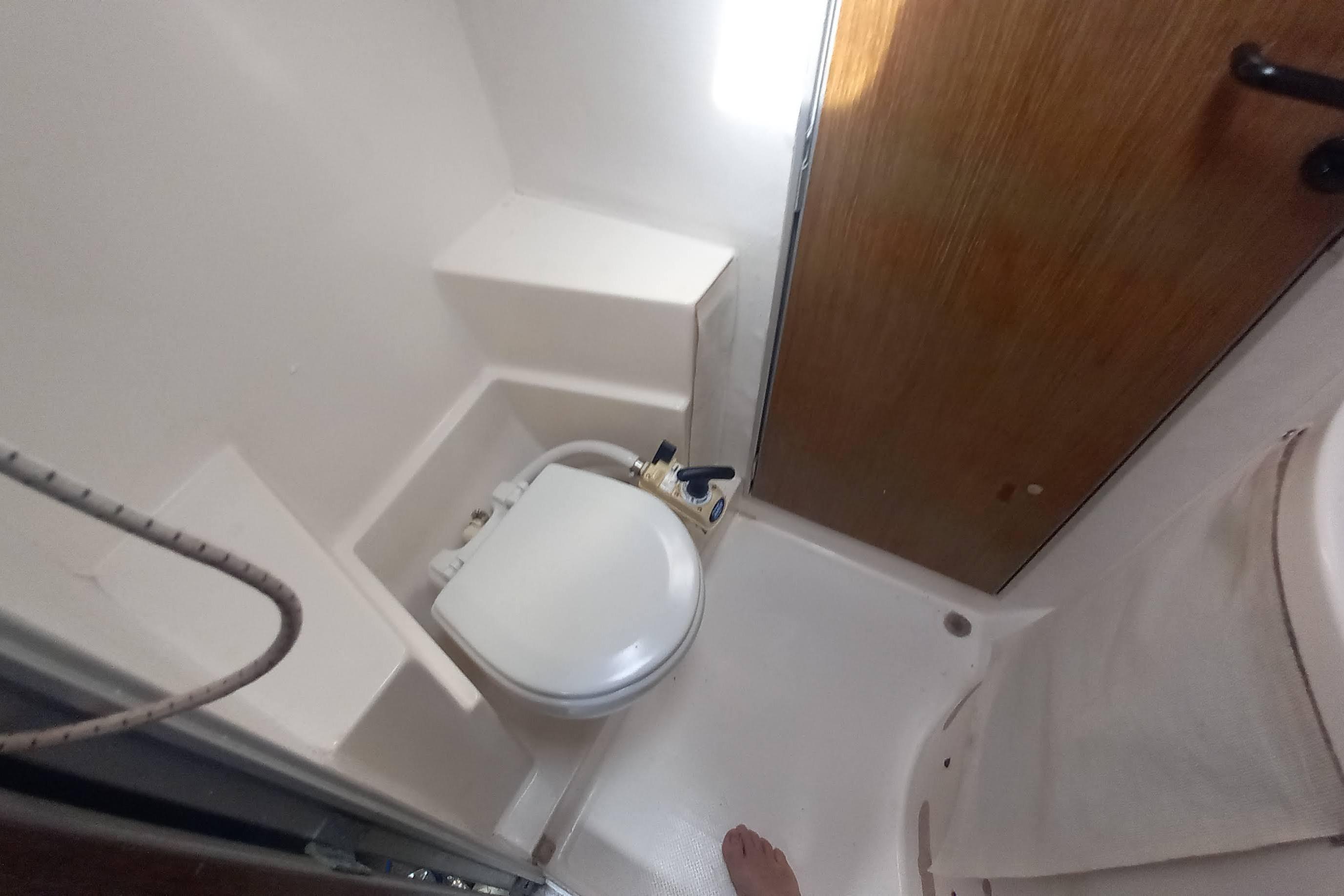 Bathroom interior of 1993 Fountaine Pajot Antigua 37 catamaran, featuring compact toilet and shower.