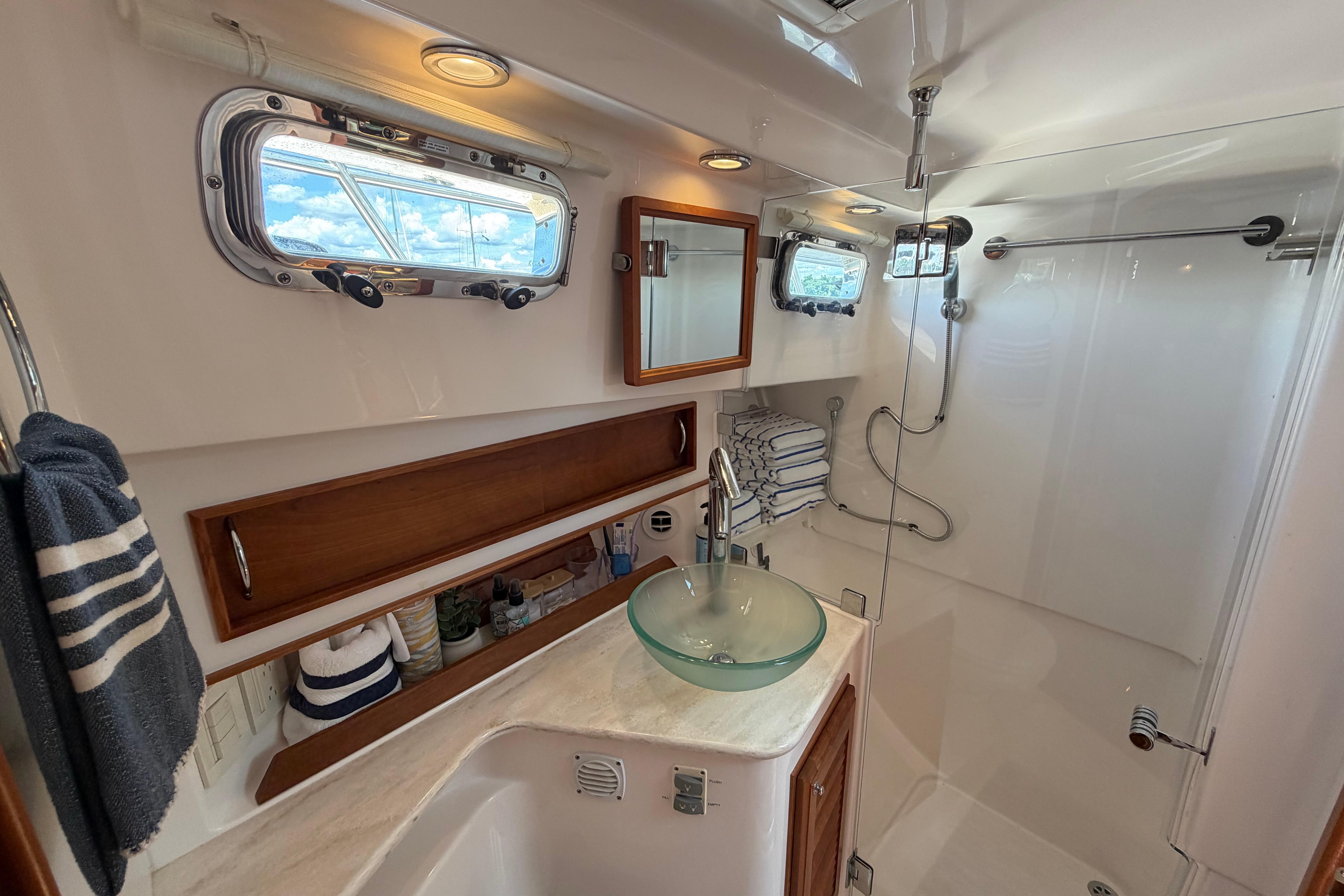 Luxurious bathroom in 2015 Sabre 38 Salon Express yacht with glass sink and shower.