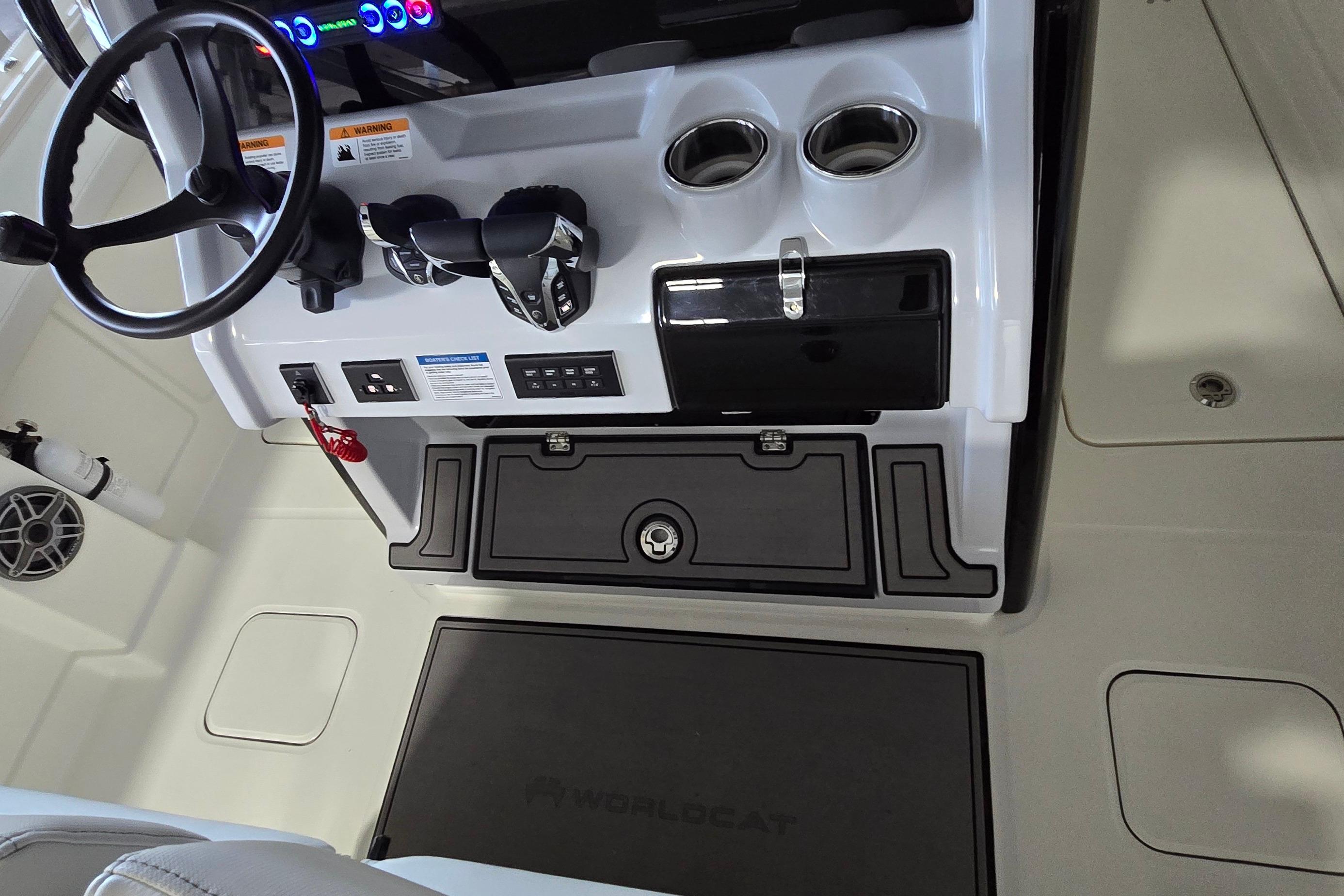 2024 WorldCat 280 CC-X boat cockpit with steering wheel, controls, and cup holders.
