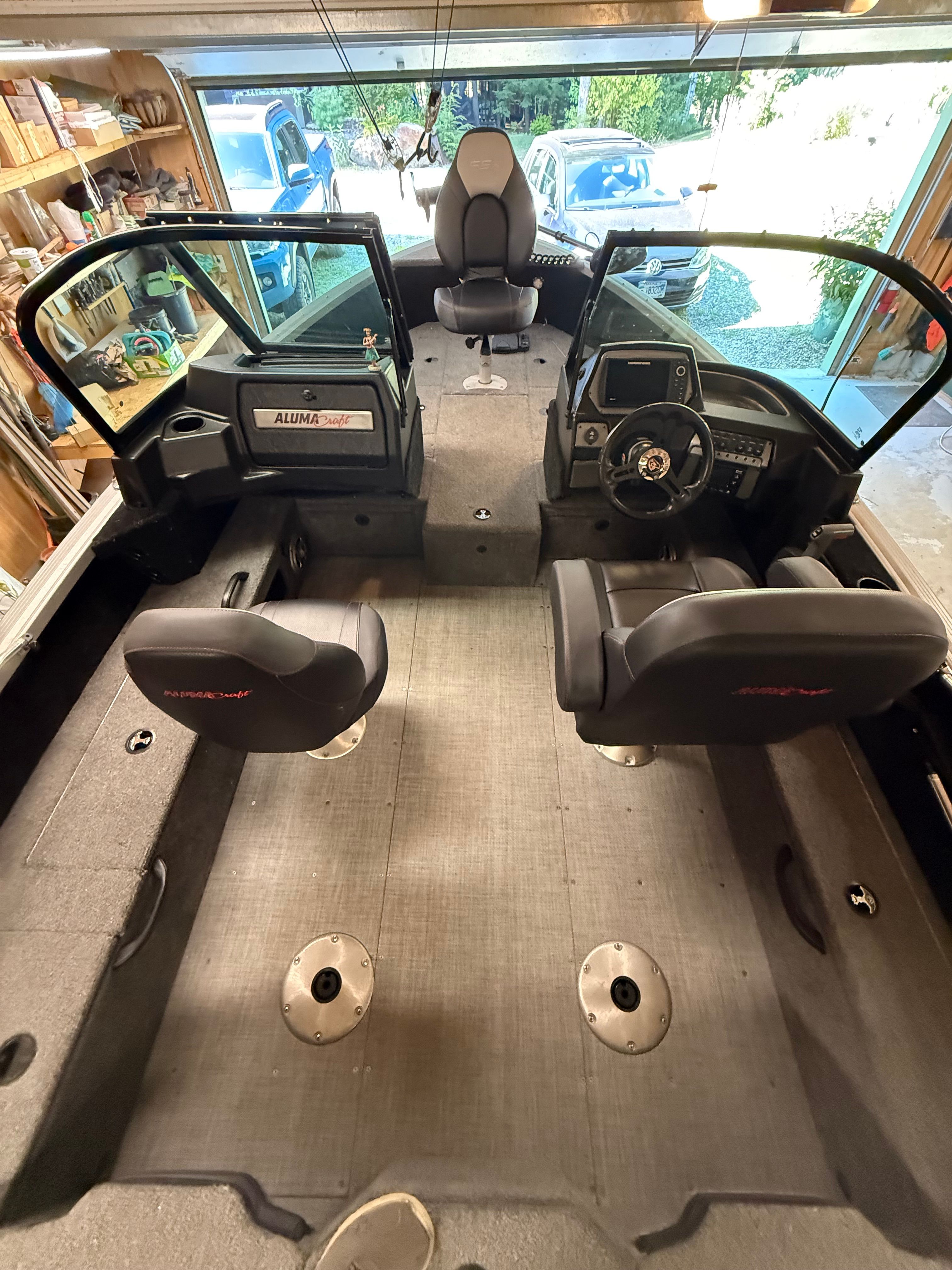 Interior view of an Alumacraft Competitor 175 Sport boat with two seats and a steering console.