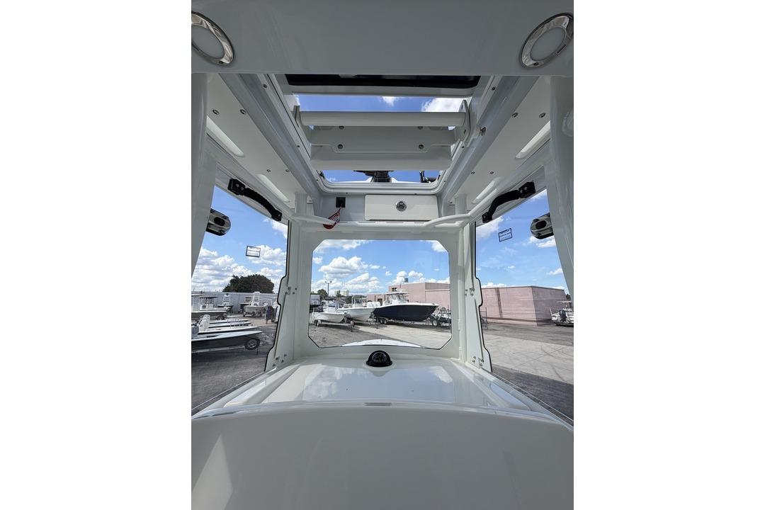 Interior view of 2026 Pathfinder 2800 Hybrid boat, showcasing open roof and docked vessels.