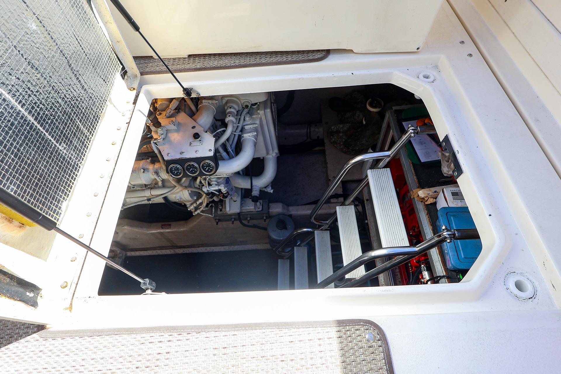 Engine compartment of a 1998 Sea Ray 500 Sundancer yacht, showing mechanical components and access ladder.