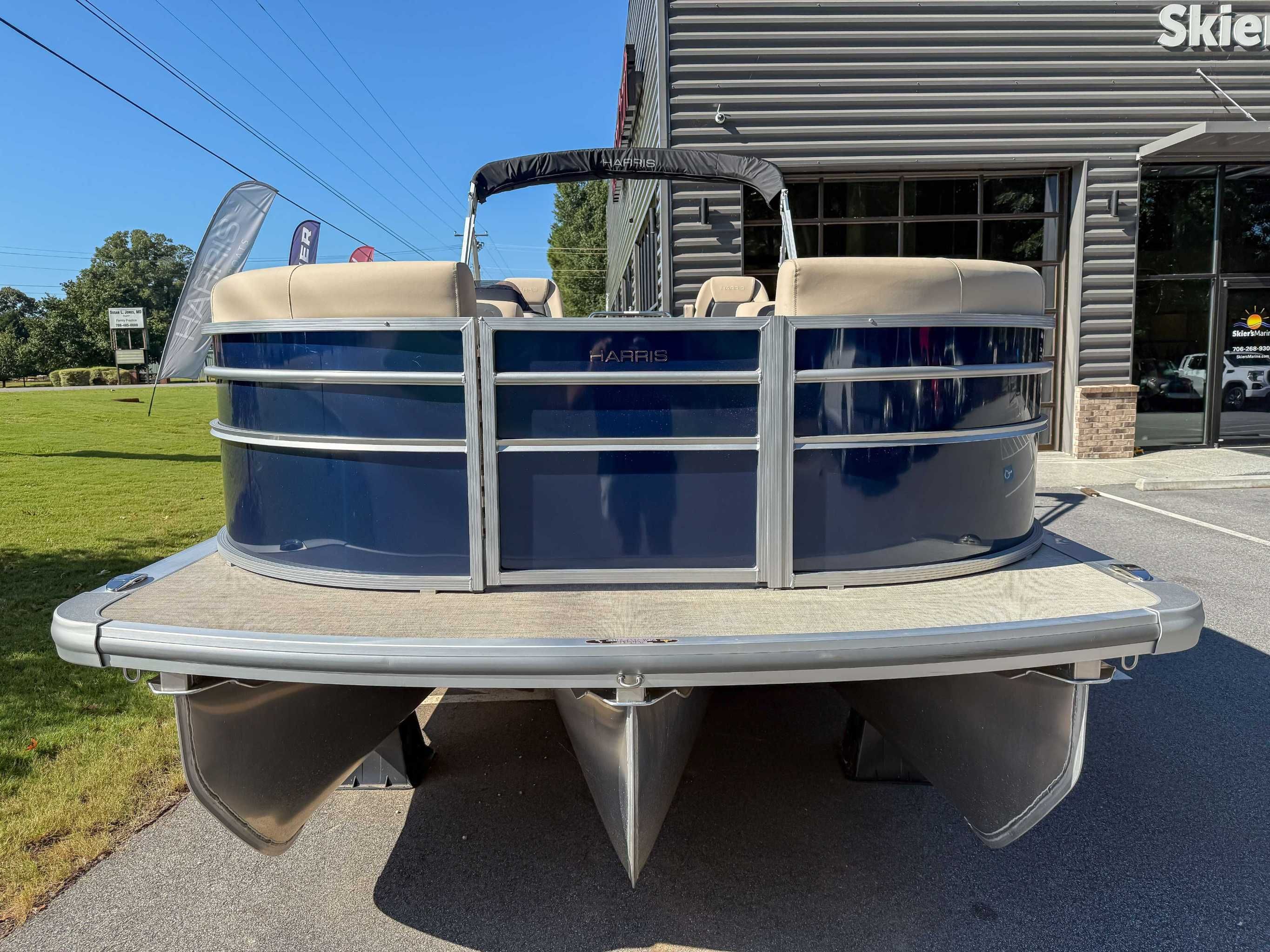 Harris Cruiser 250 CWDH 2025 pontoon boat in front of a building.