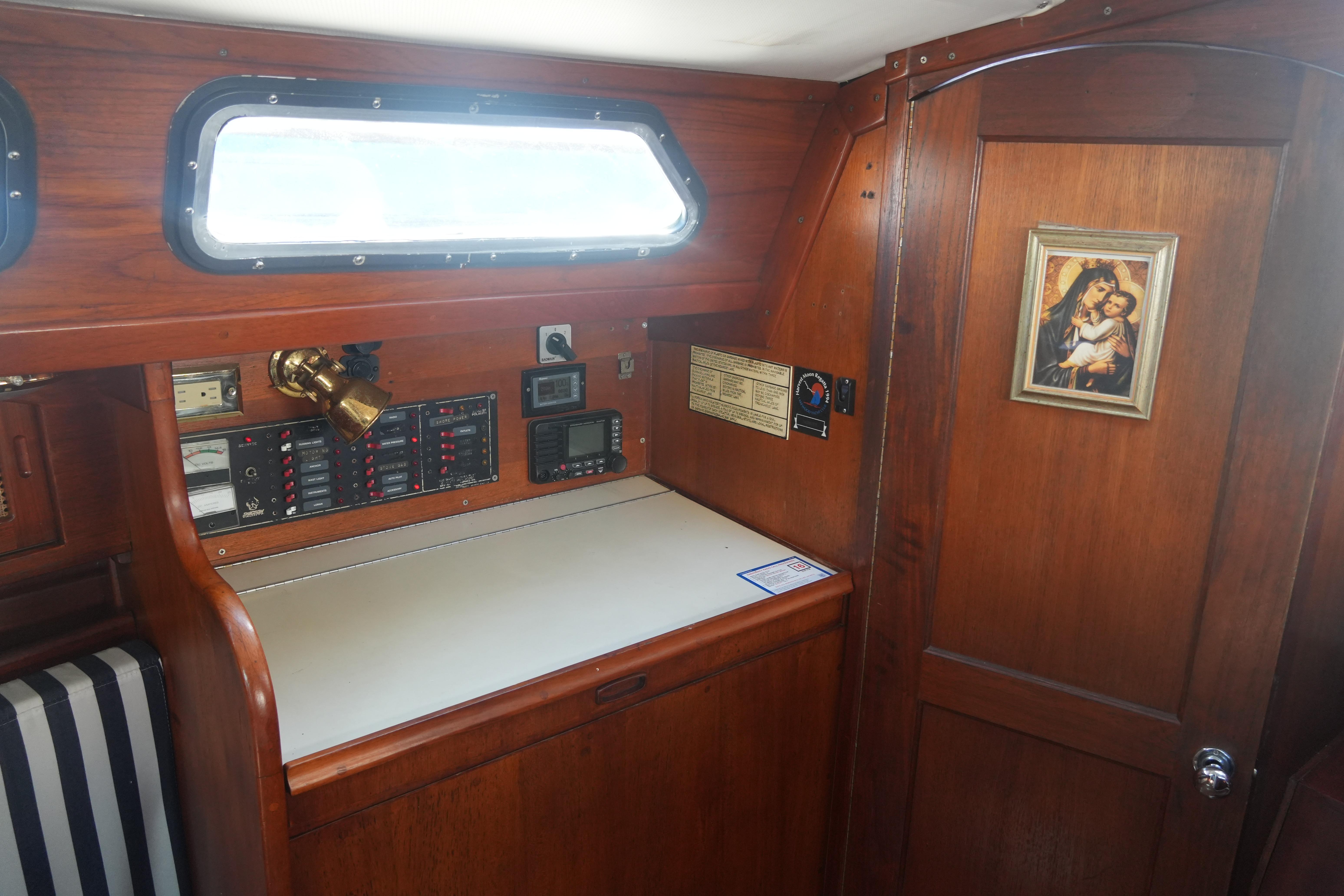 Interior of 1987 Ericson 32-200 sailboat with navigation station and religious artwork.